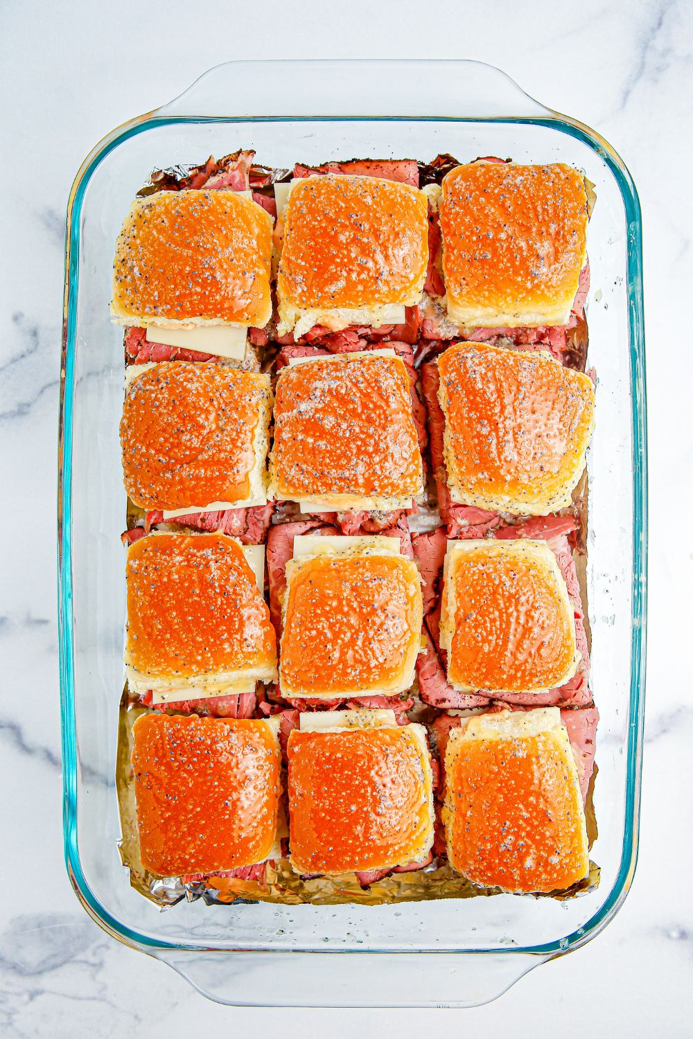 buttered sliders in a baking dish
