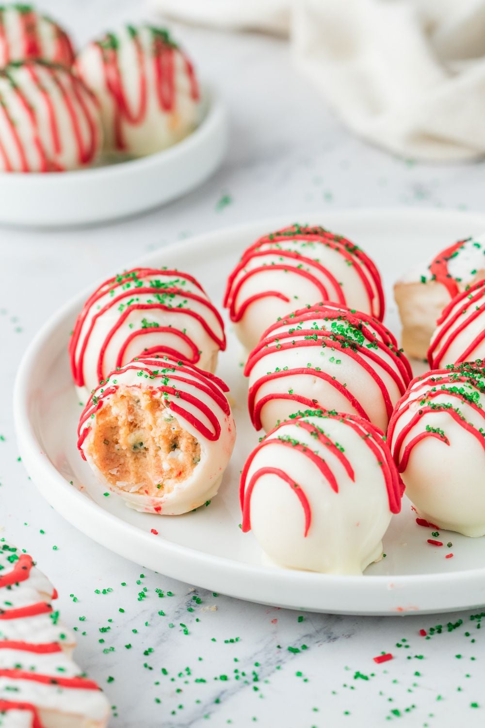 cake truffles on a plate with one that has a bite taken out of it