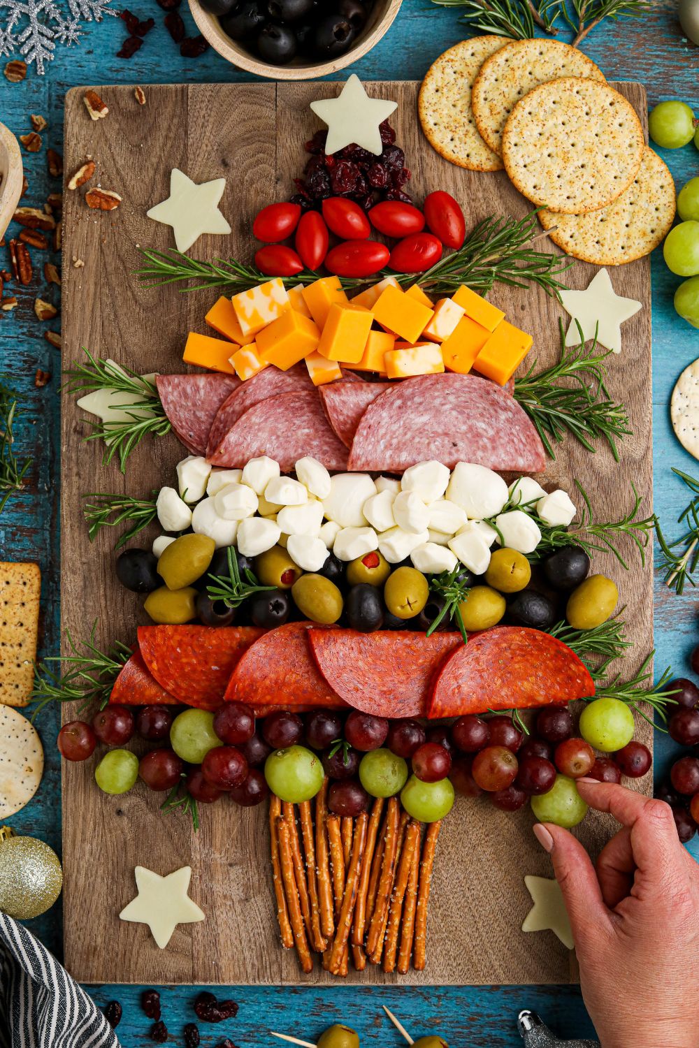 grabbing a grape off a snacking board that is on table