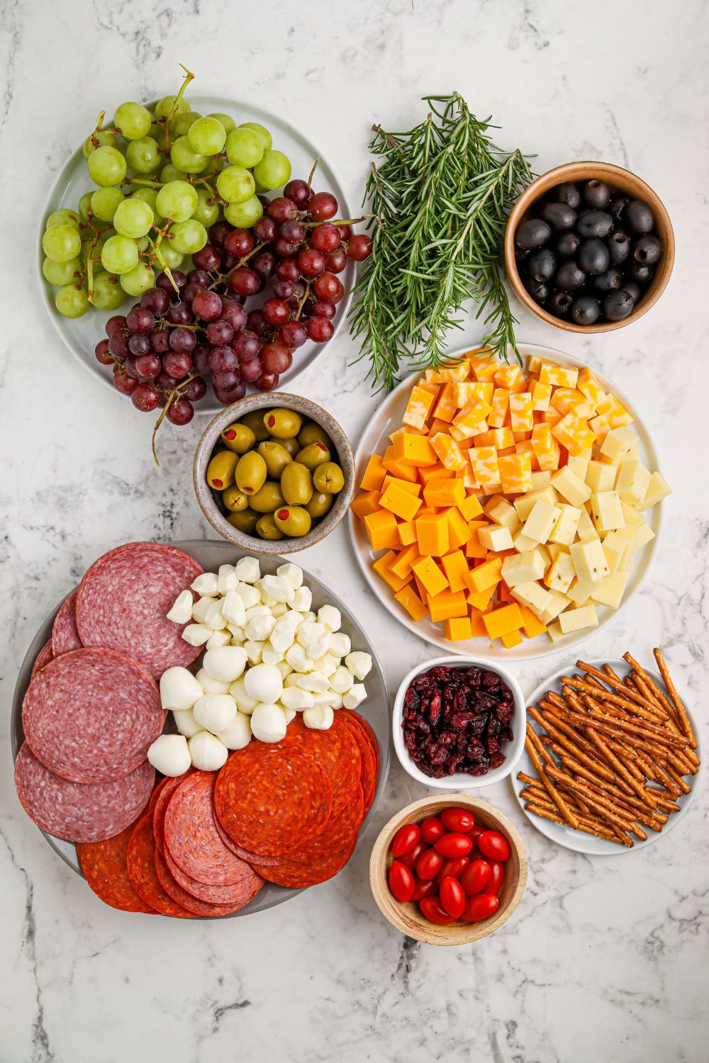 christmas charcuterie board ingredients on marble counter