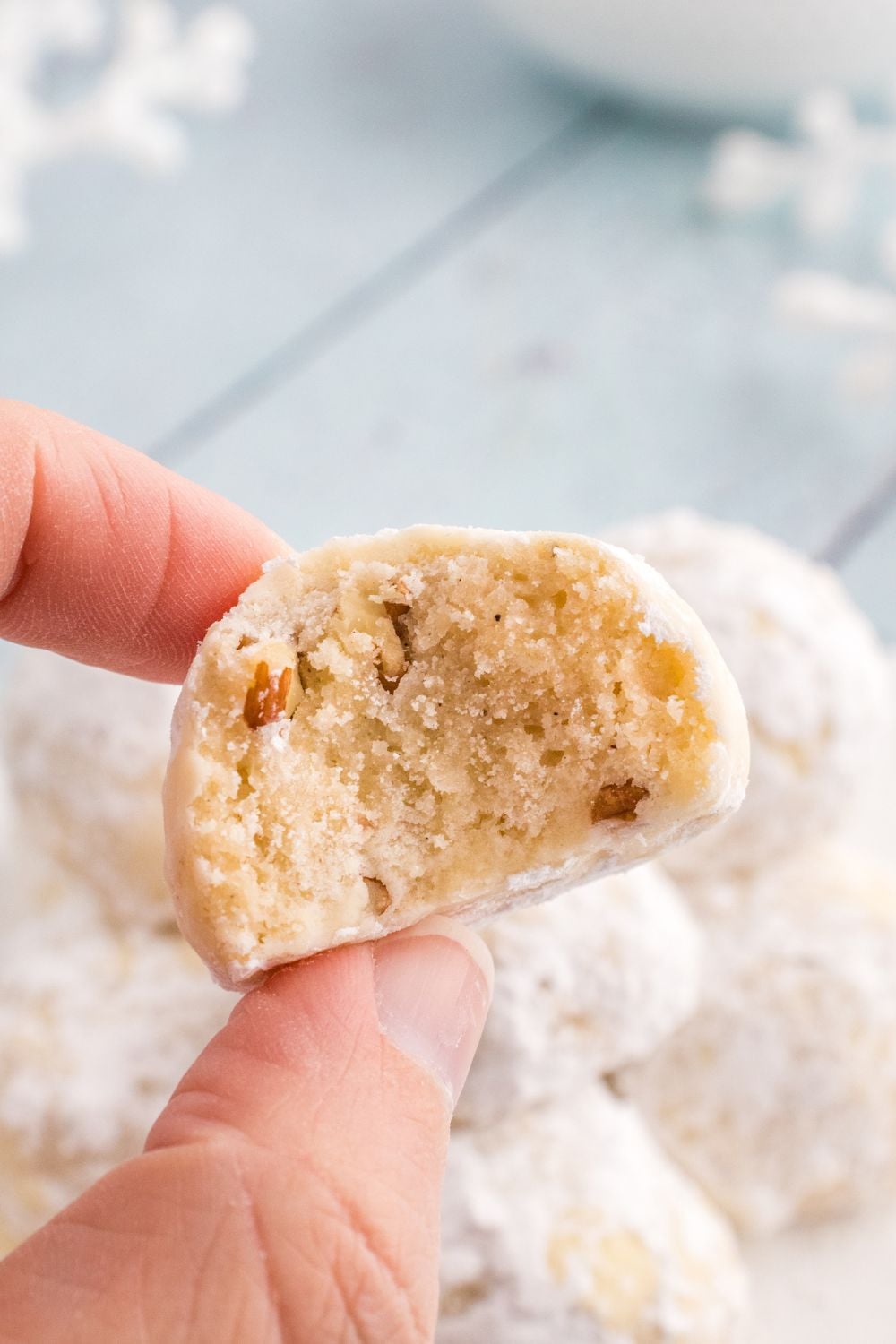 christmas snowball cookie in hand with bite taken out of it