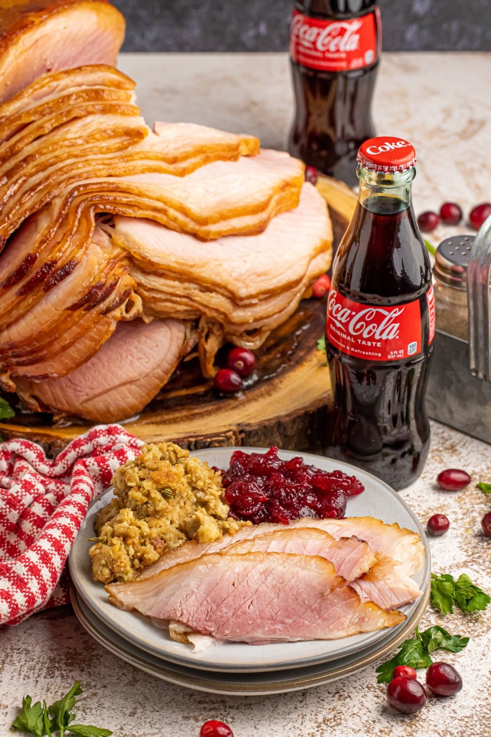 ham dinner on table with bottles of coke sitting by the rest on ham on platter