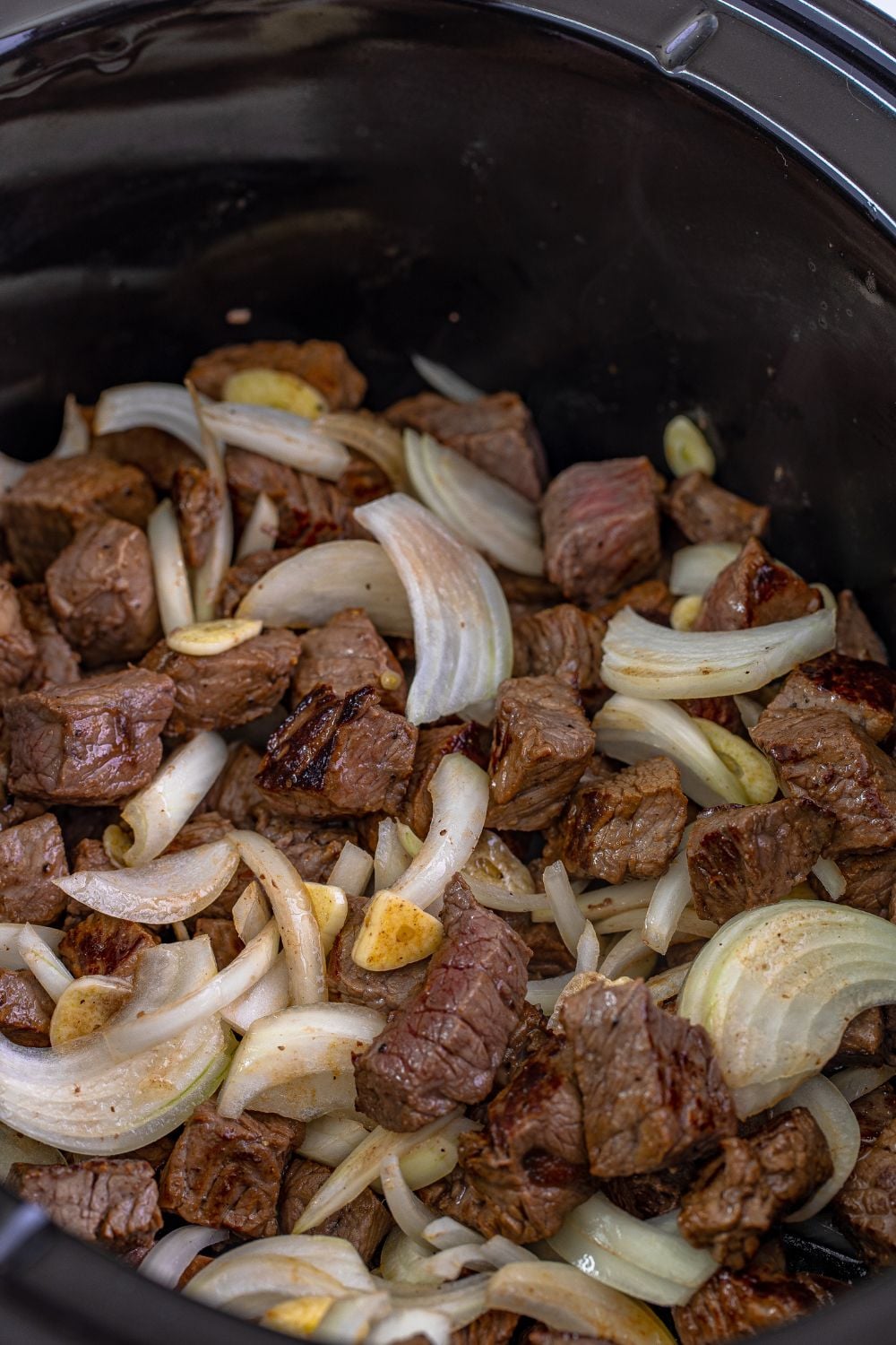 seared steak and veggies mixed up in a slow cooker