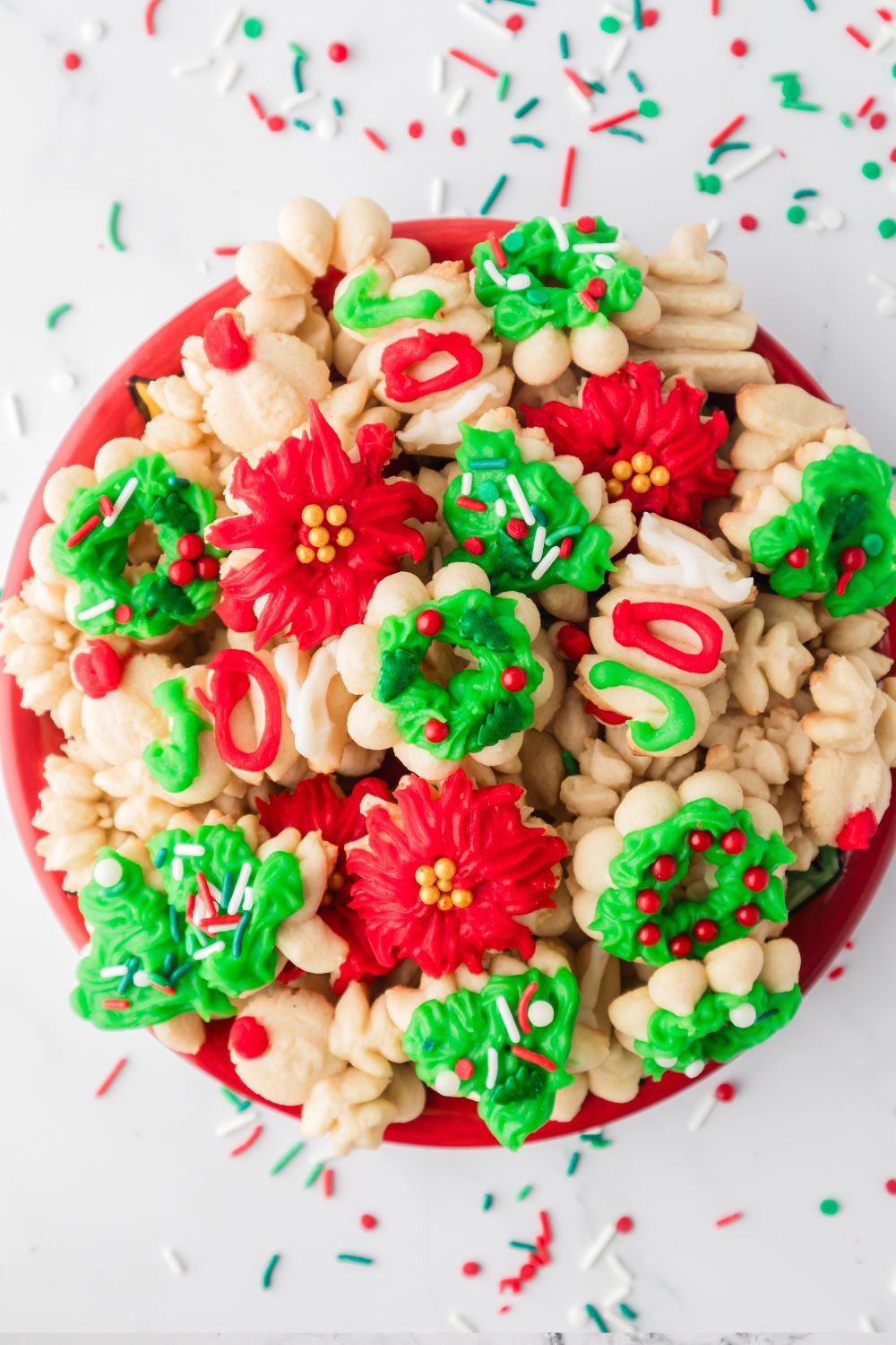 plate with spritzer cookies on it and sprinkles around it