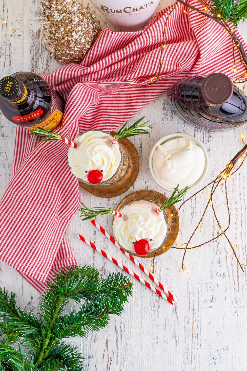 overhead view of milkshakes in glasses on table with christmas decor around it