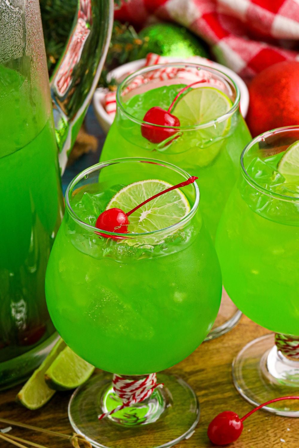 Lime flavored punch in glasses with lime wedge and cherries on top of glass