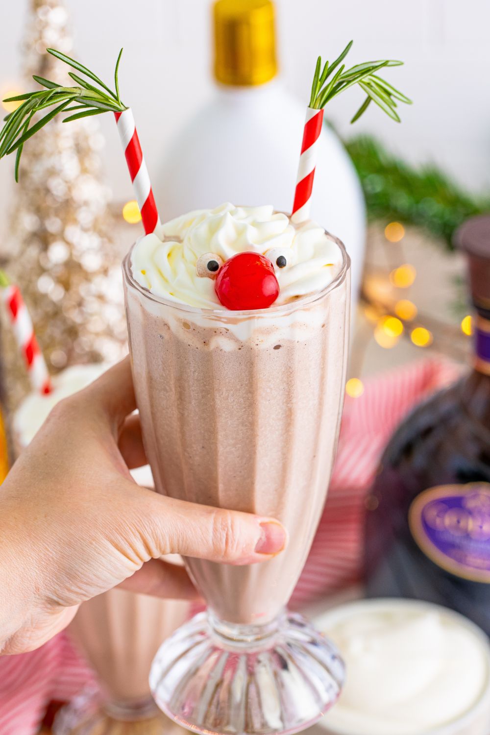 holding milkshake in hand above table