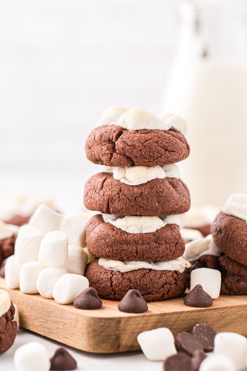 stacked cookies on a table with milk behind it