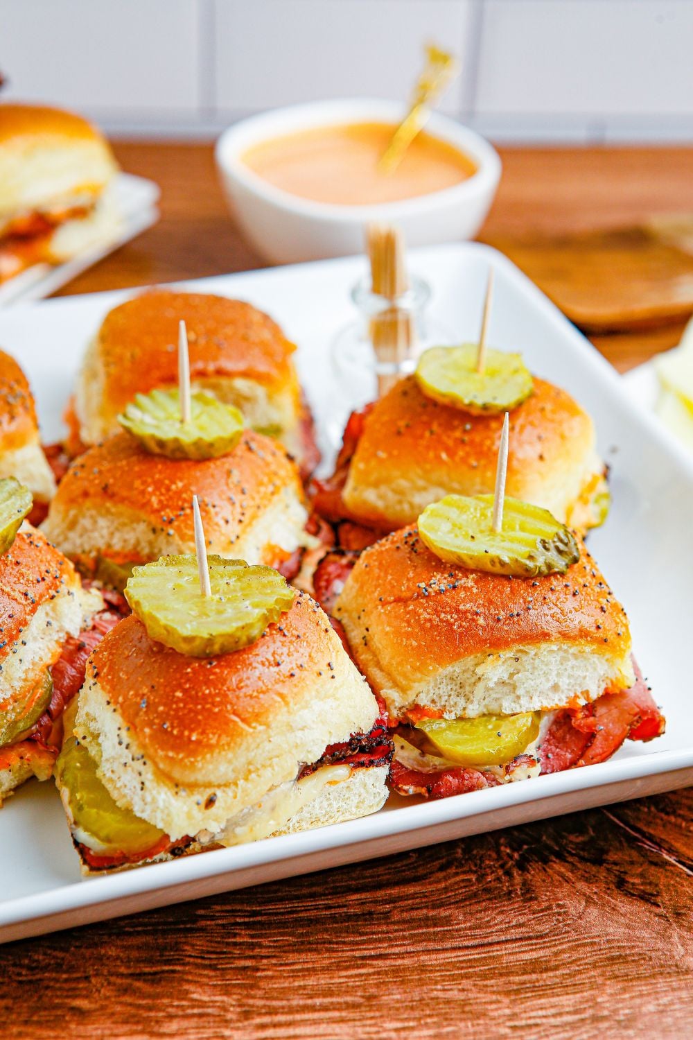 mini slider appetizer on tray with sauce behind it in bowl