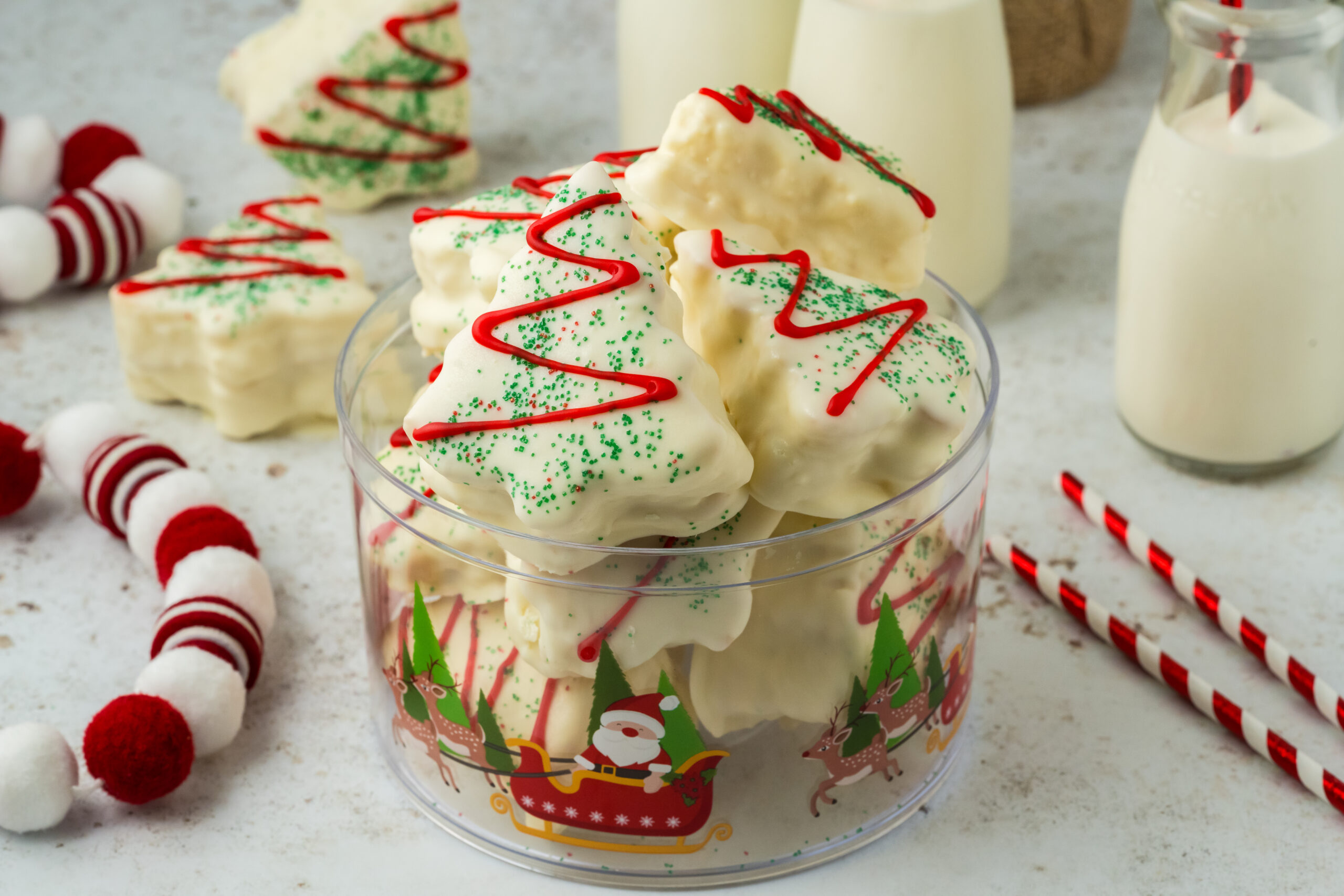 cakes in a glass bowl on table with Christmas decor around it