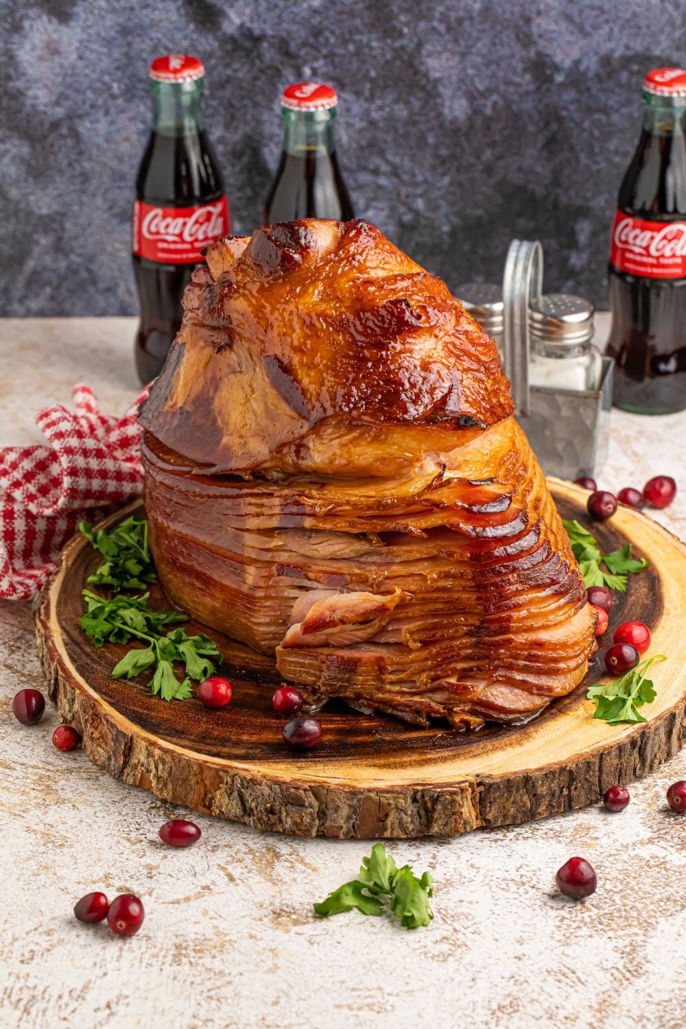 ham on a platter on table with coke bottles in the background