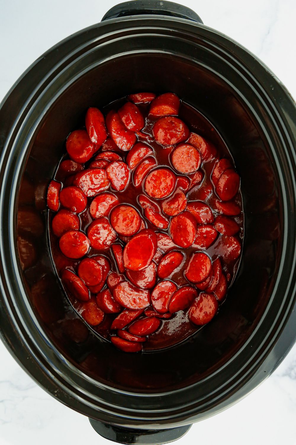 overhead shot of kielbasa bites in slow cooker