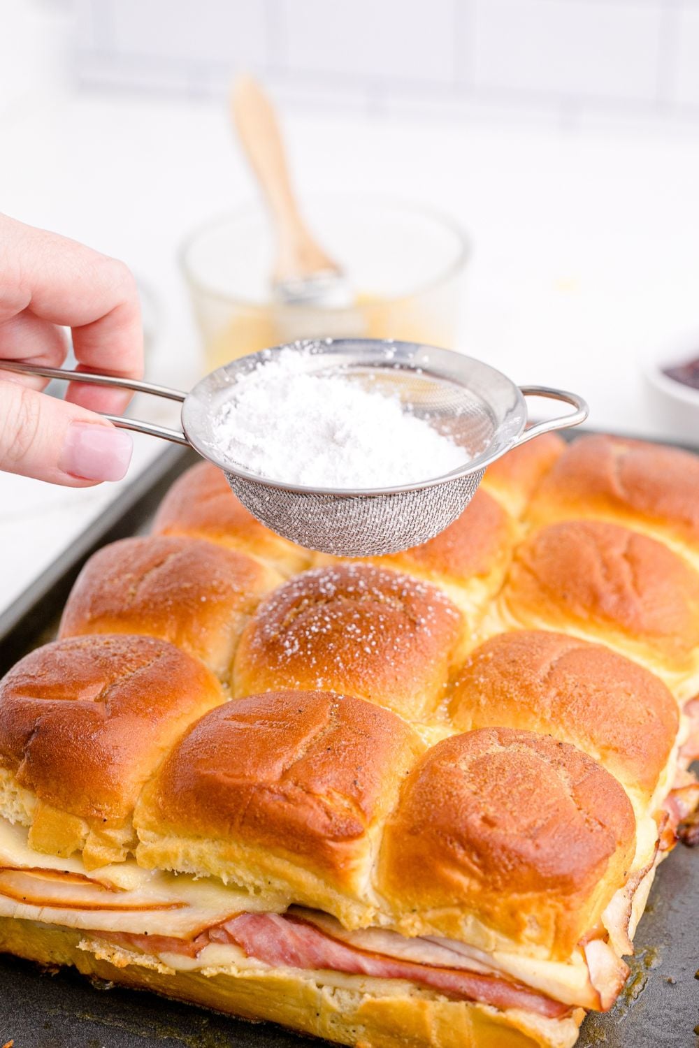 dusting top of buns with powdered sugar