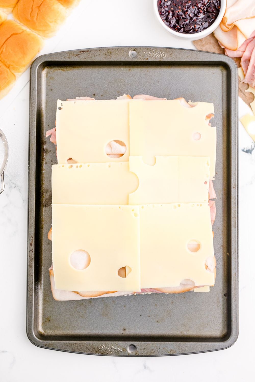 swiss cheese on top of meat and buns