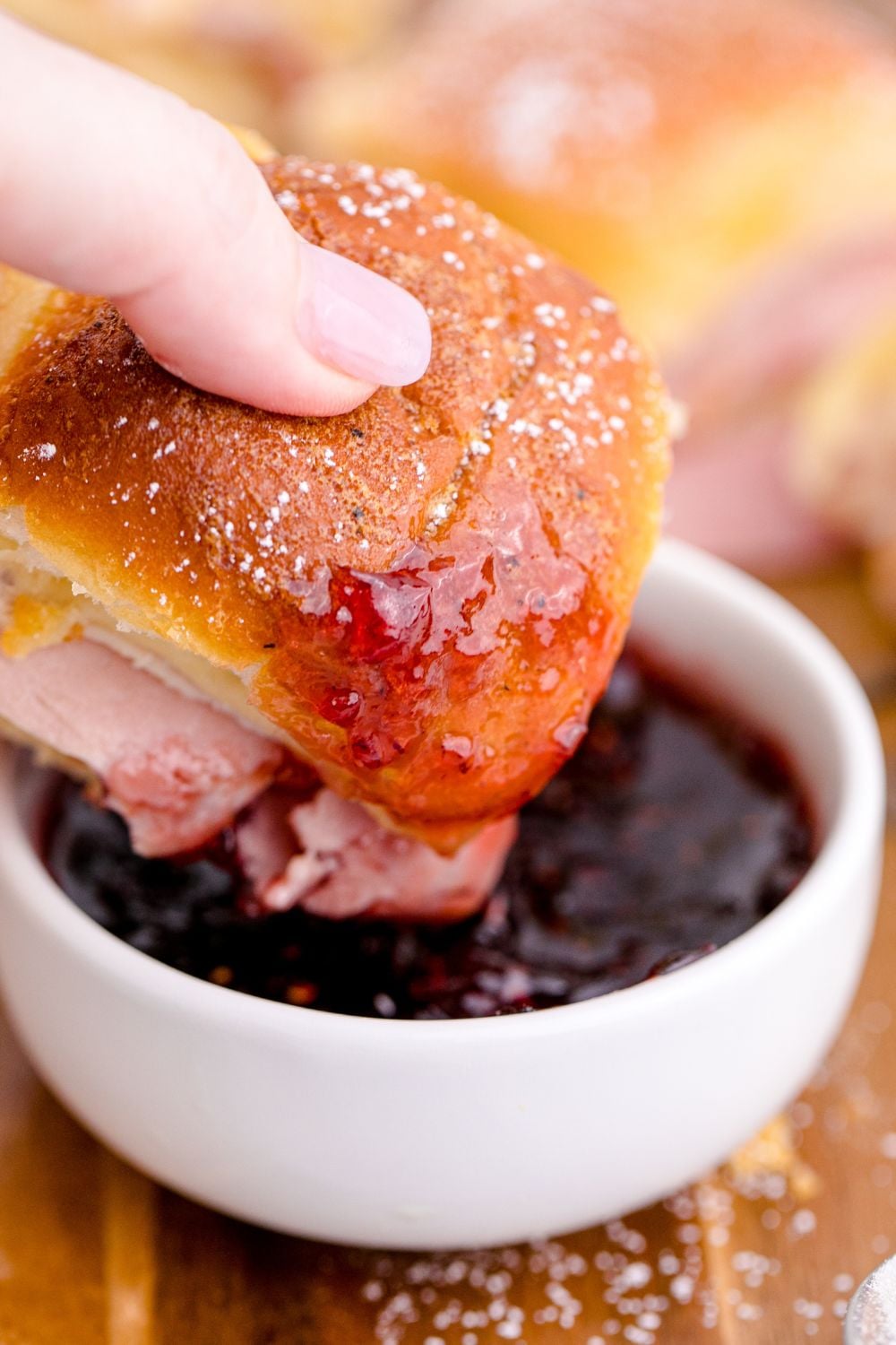 dipping a sauce in fruit jam on table