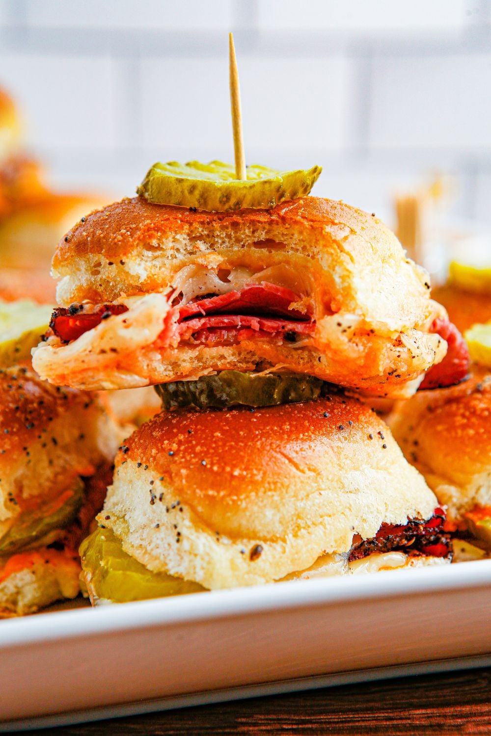pastrami sliders on hawaiian rolls stacked on plate