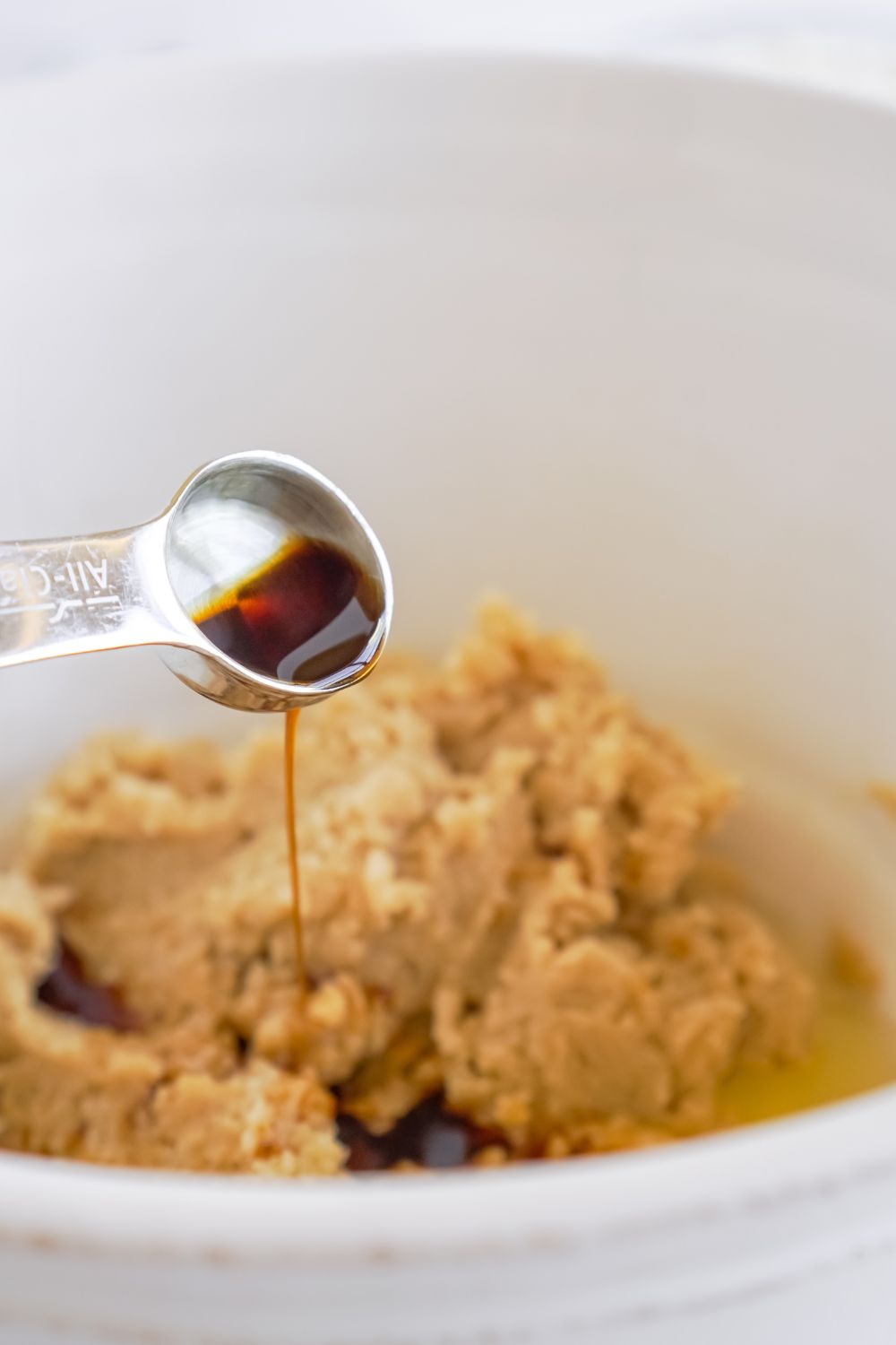 vanilla being poured into a cookie dough batter