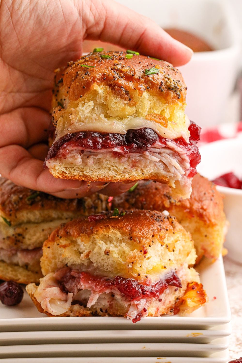 sliders with deli meat in hands