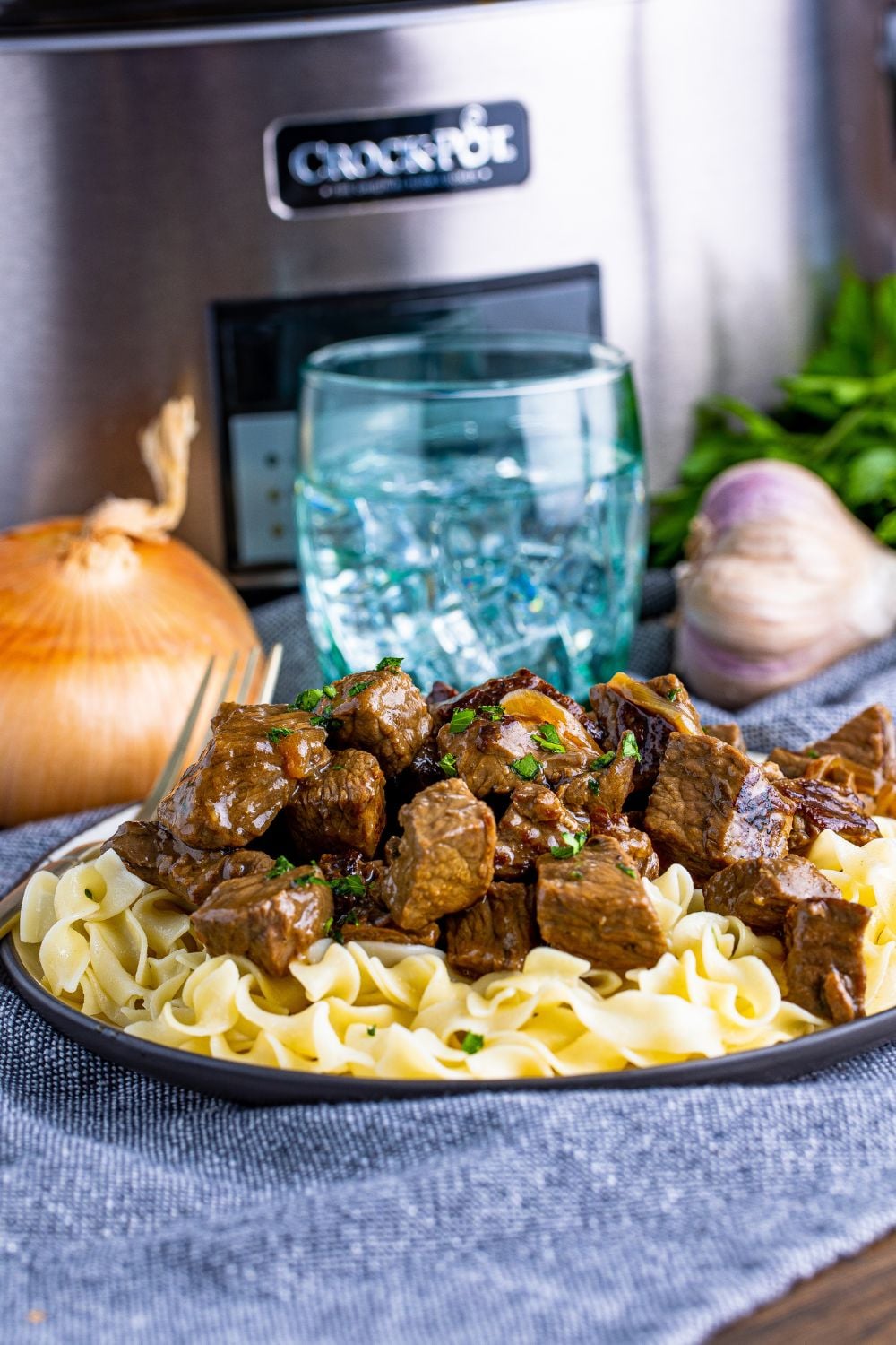 steak on a plate with noodles under it