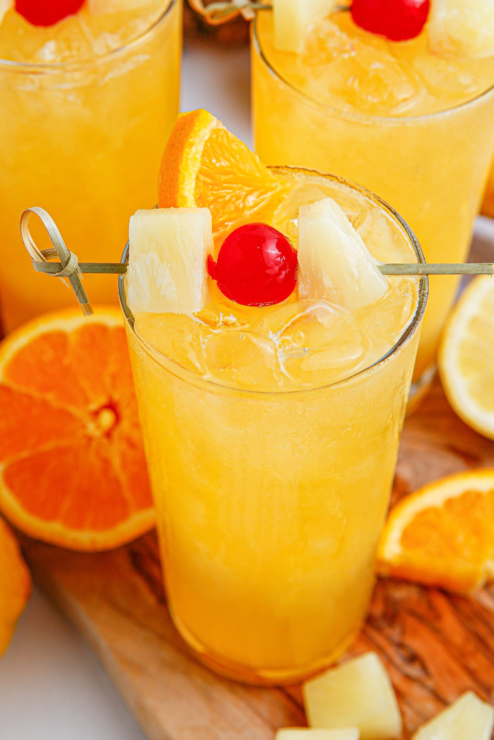 glass of punch on table with orange and cherry on top 