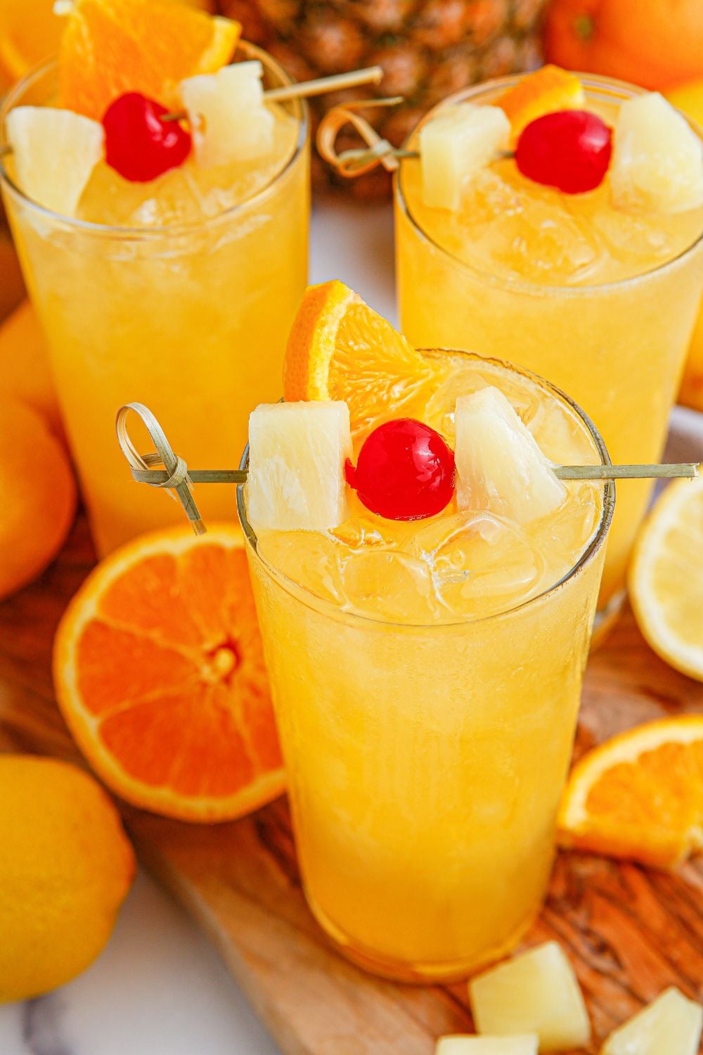Tropical Lemonade Punch in glasses on table with fruit around it on table 