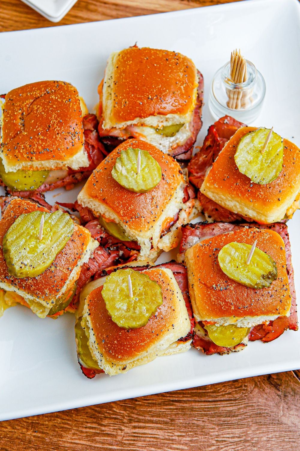 Pastrami Sliders on a table with pickles on top