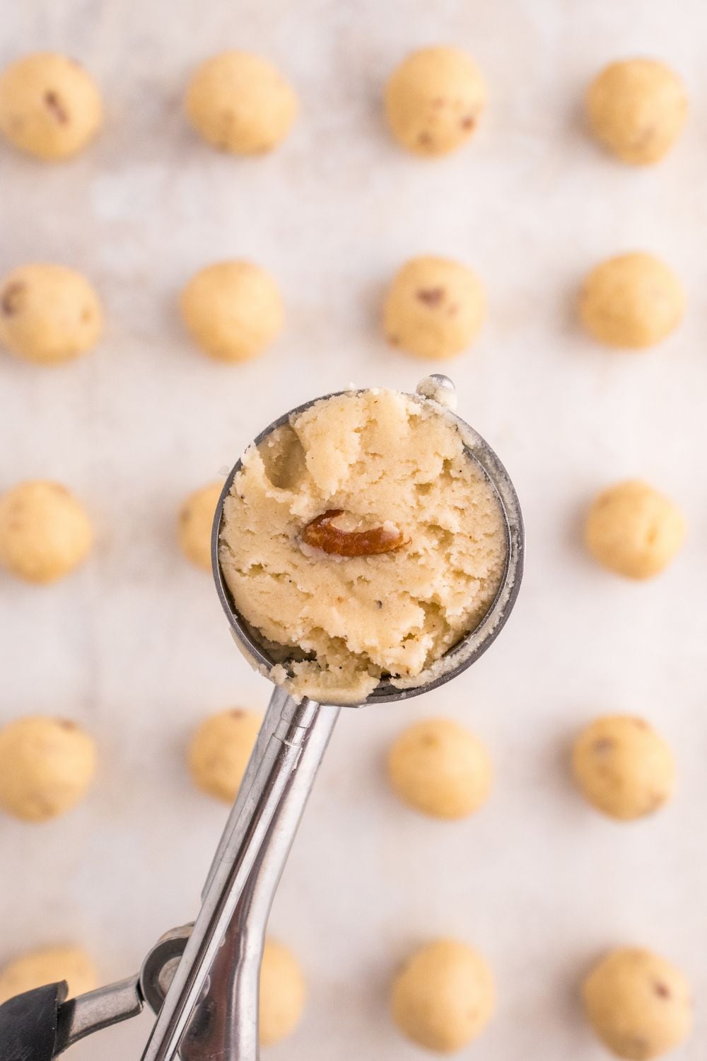 cookie scoop with snowball cookie batter in it