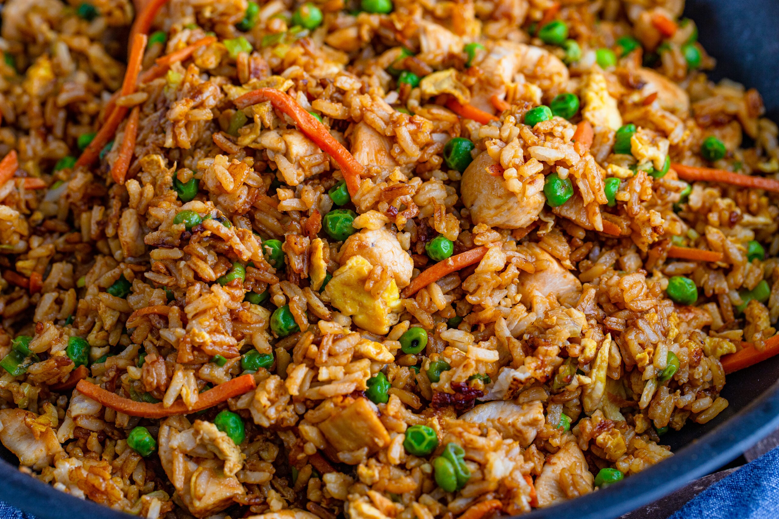 overhead view of chicken fried rice in a skillet with veggies and eggs