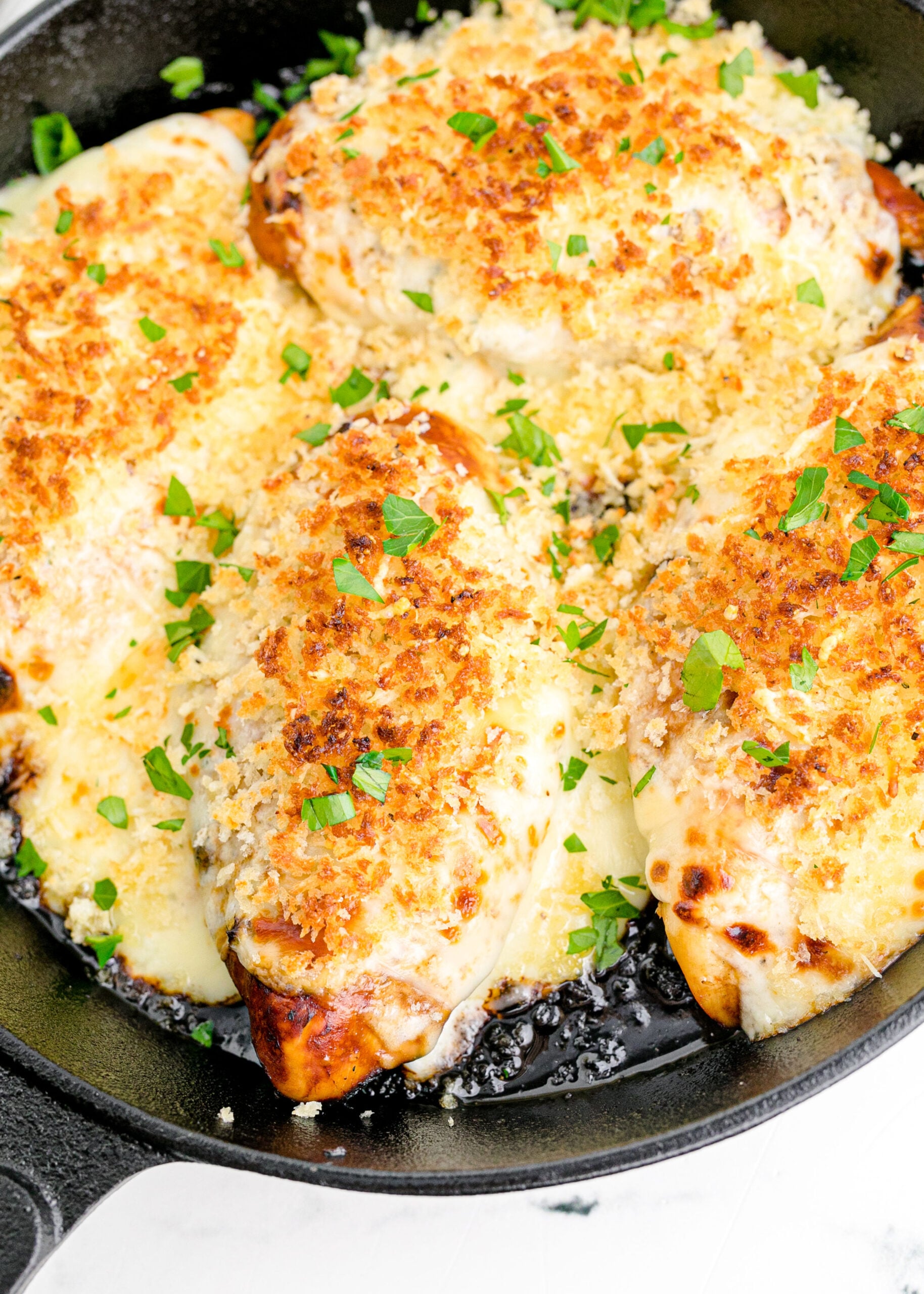Close up view of Parmesan Crusted Chicken (Longhorn Copycat) in a cast iron skillet.