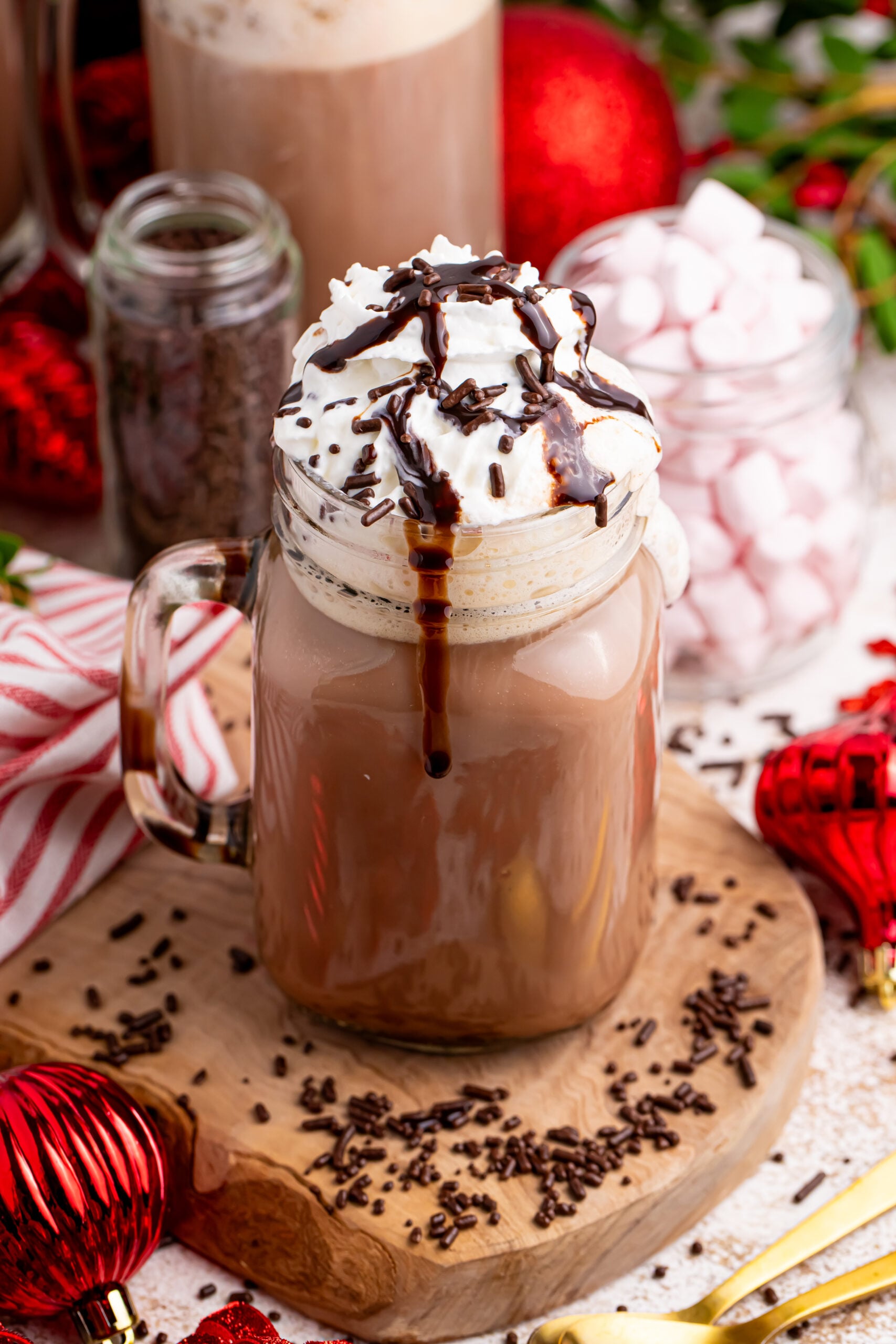 Dirty Snowman on the table on a coaster with Christmas decorations around the glass with chocolate syrup drizzle
