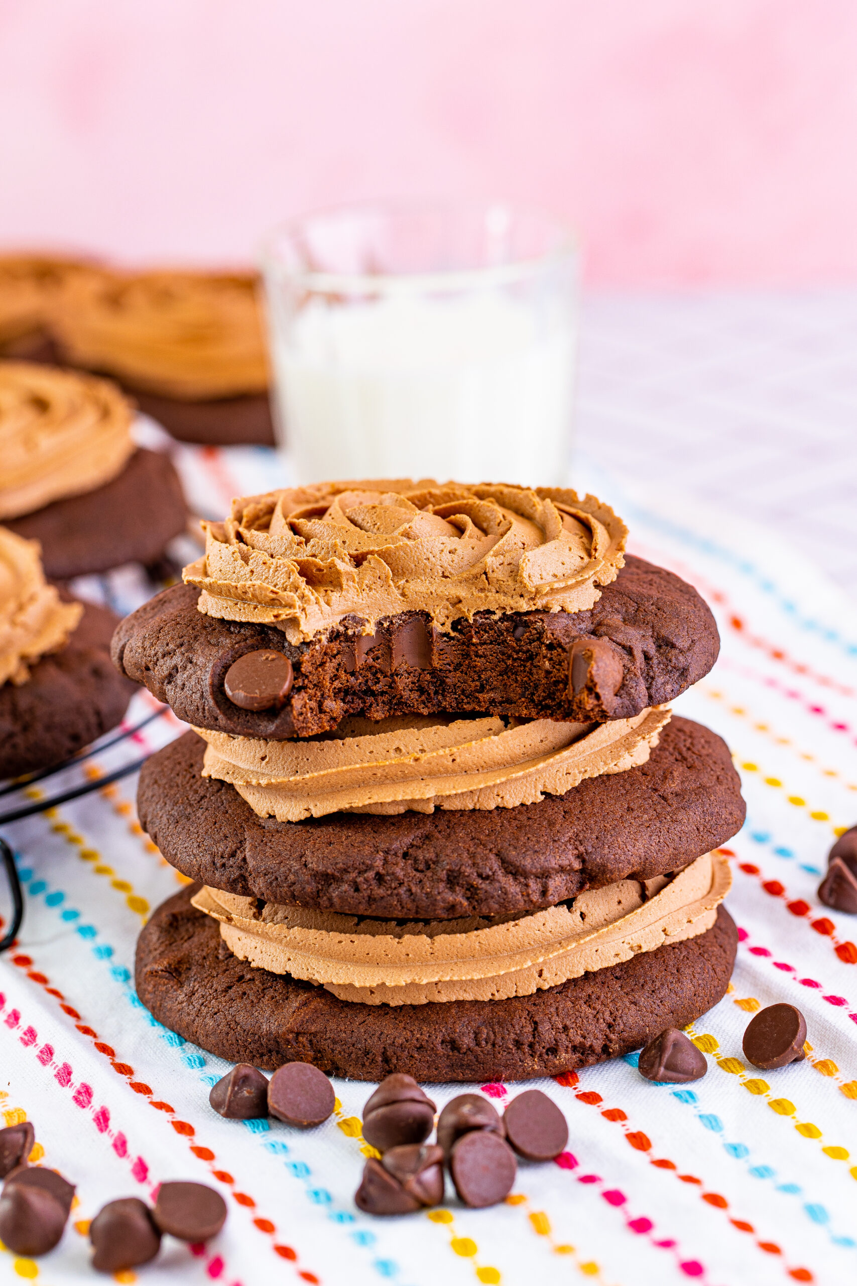 Chocolate Cake Cookies stacked with frosting and a bite missing from the top one 