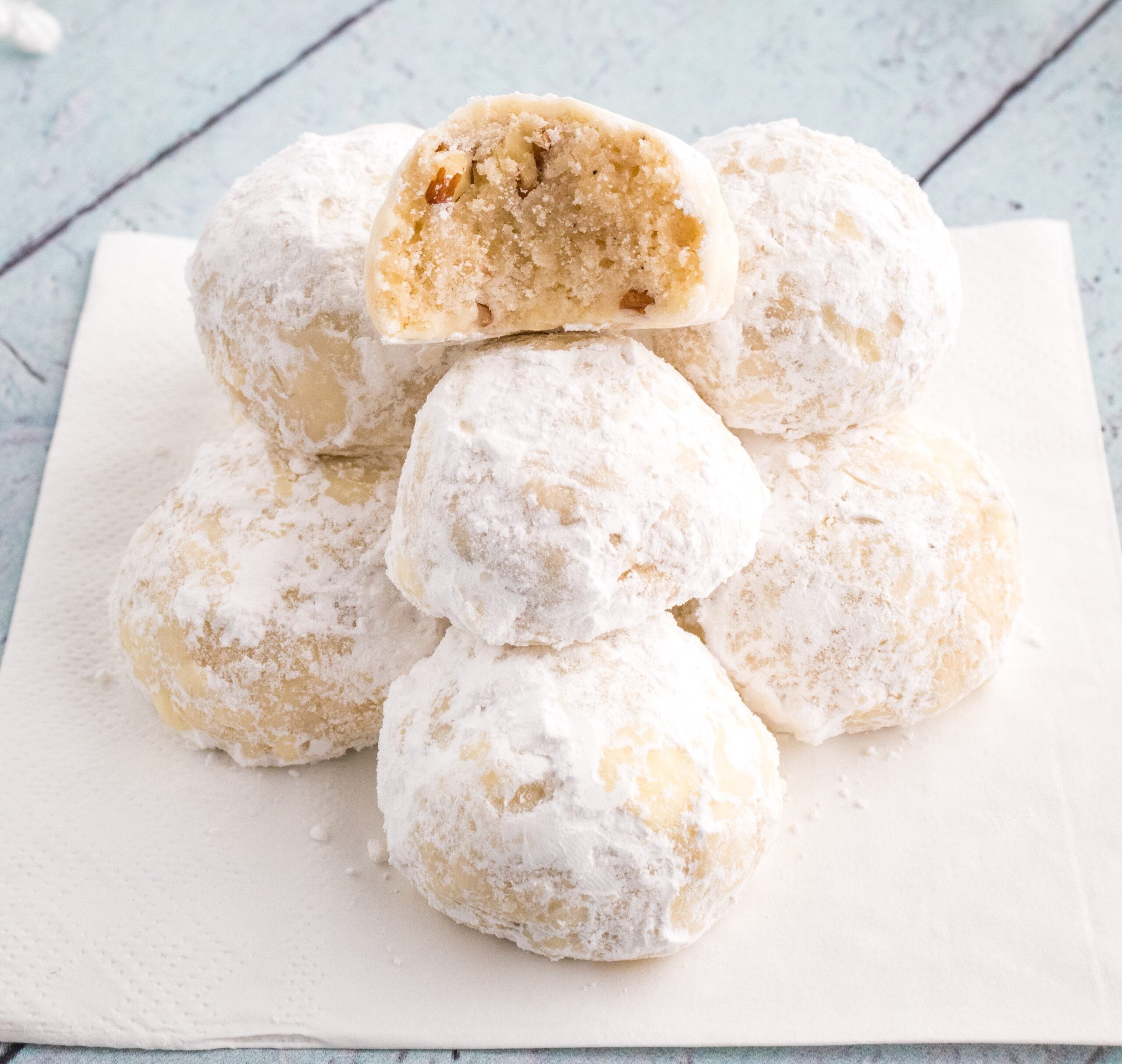 Snowball Cookies on table with one that has a bite taken out of it