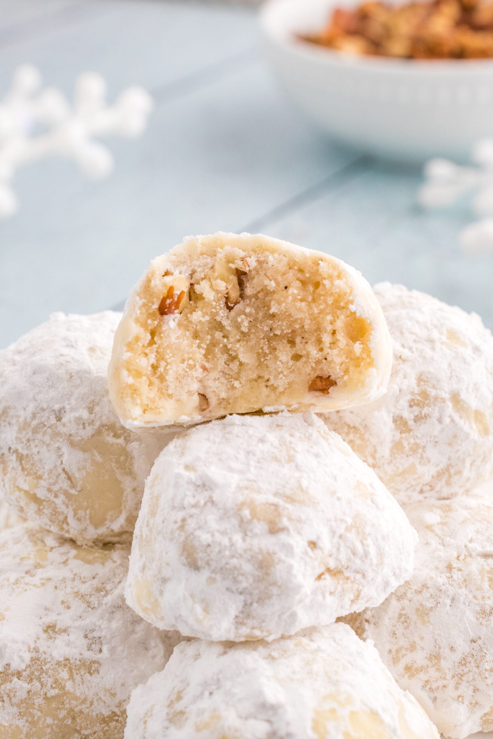 Snowball Cookies on table with one that has a bite taken out of it