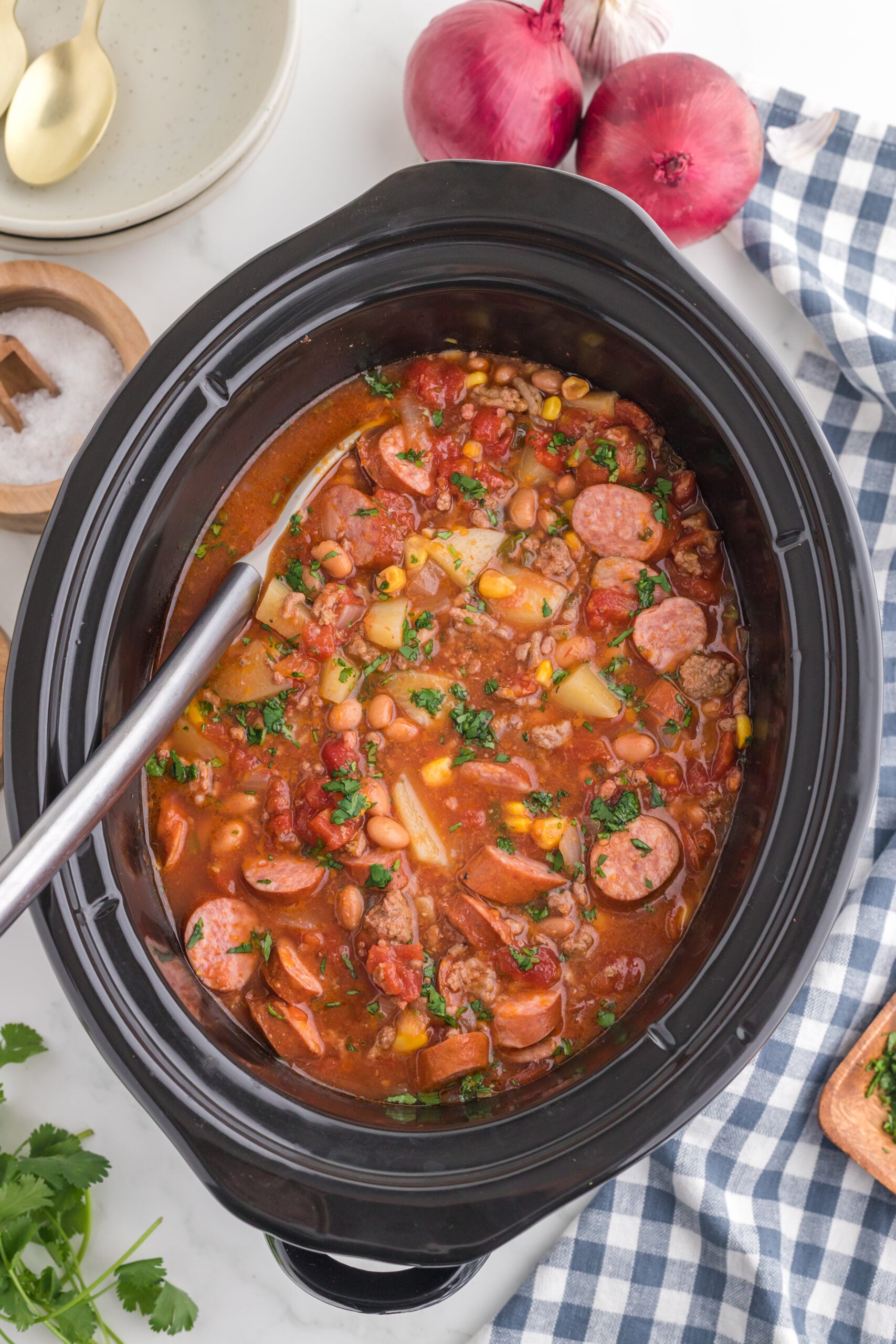 Slow Cooker Texas Cowboy Stew in a crock pot with a metal spoon in the slow cooker