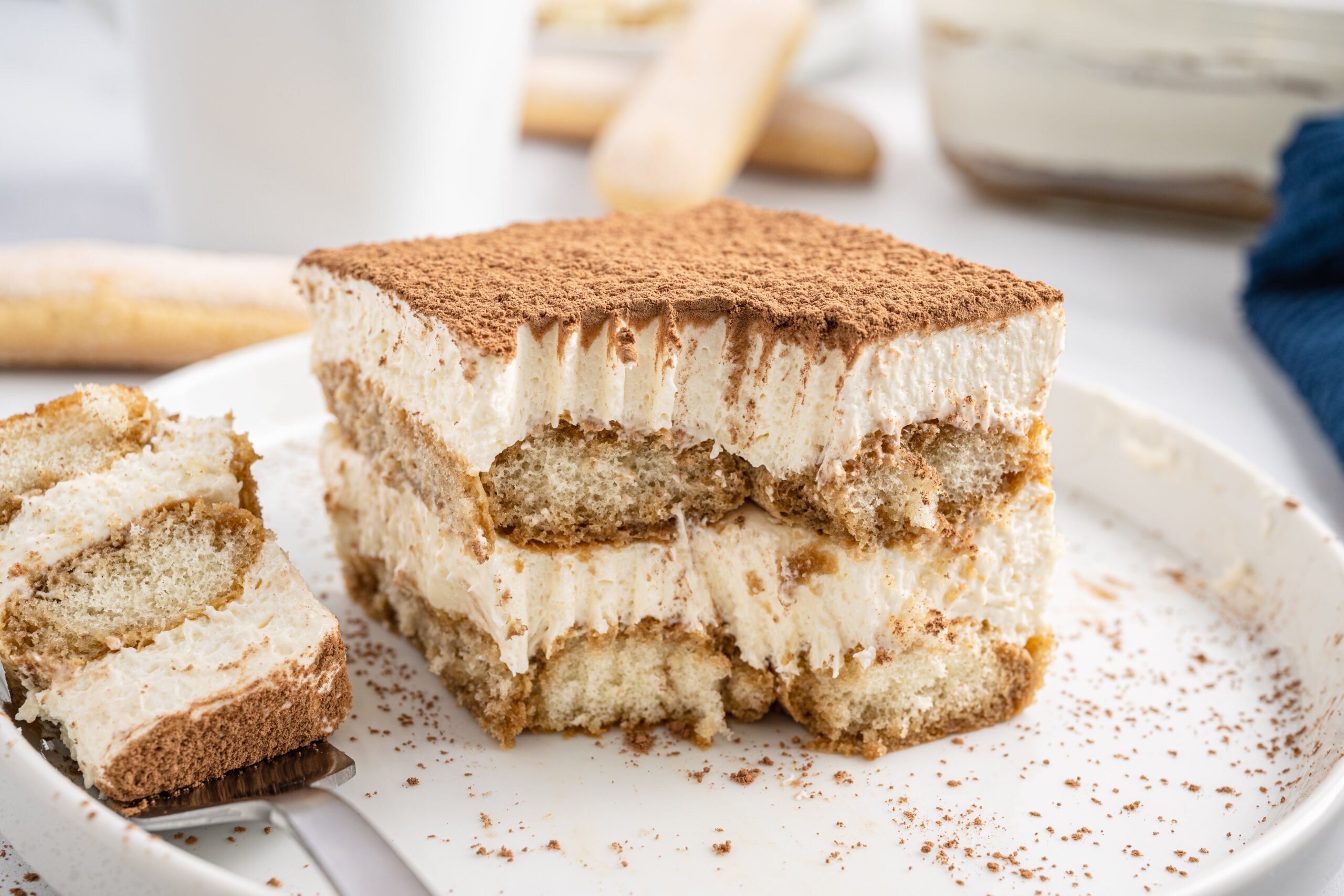 Tiramisu on a white plate with a bite removed