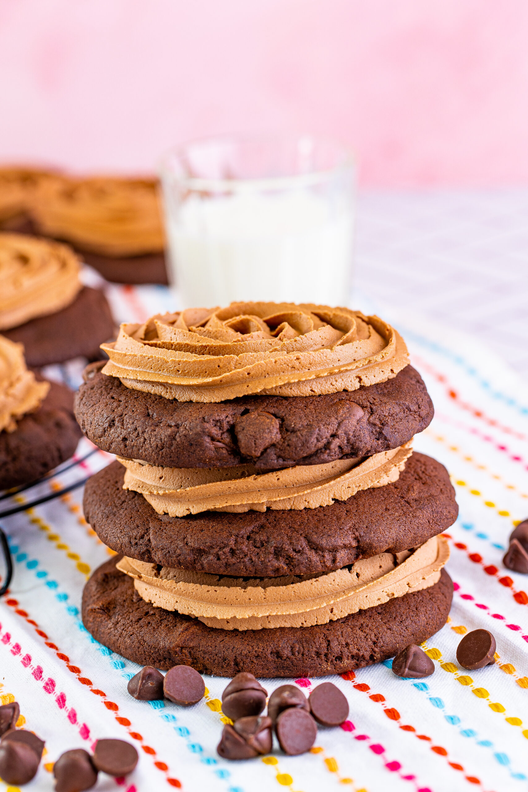 Chocolate Cake Cookies stacked with frosting with a cup of milk in the background