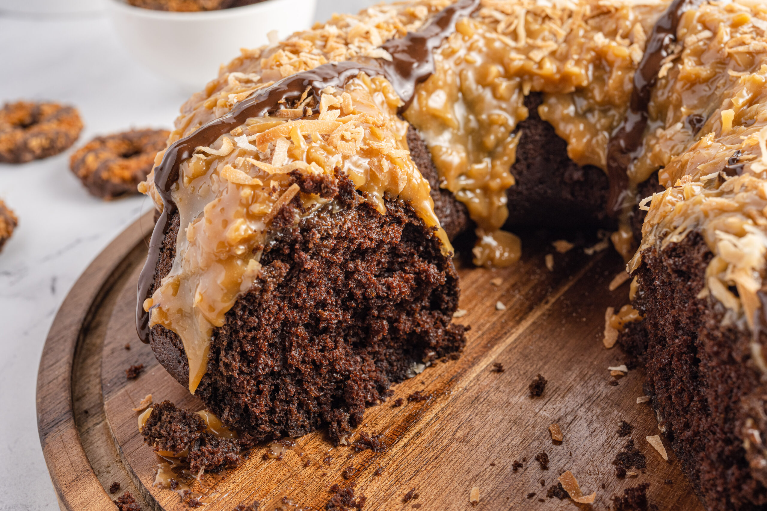 Close up view of Samoa Cake on a wooden cutting board.