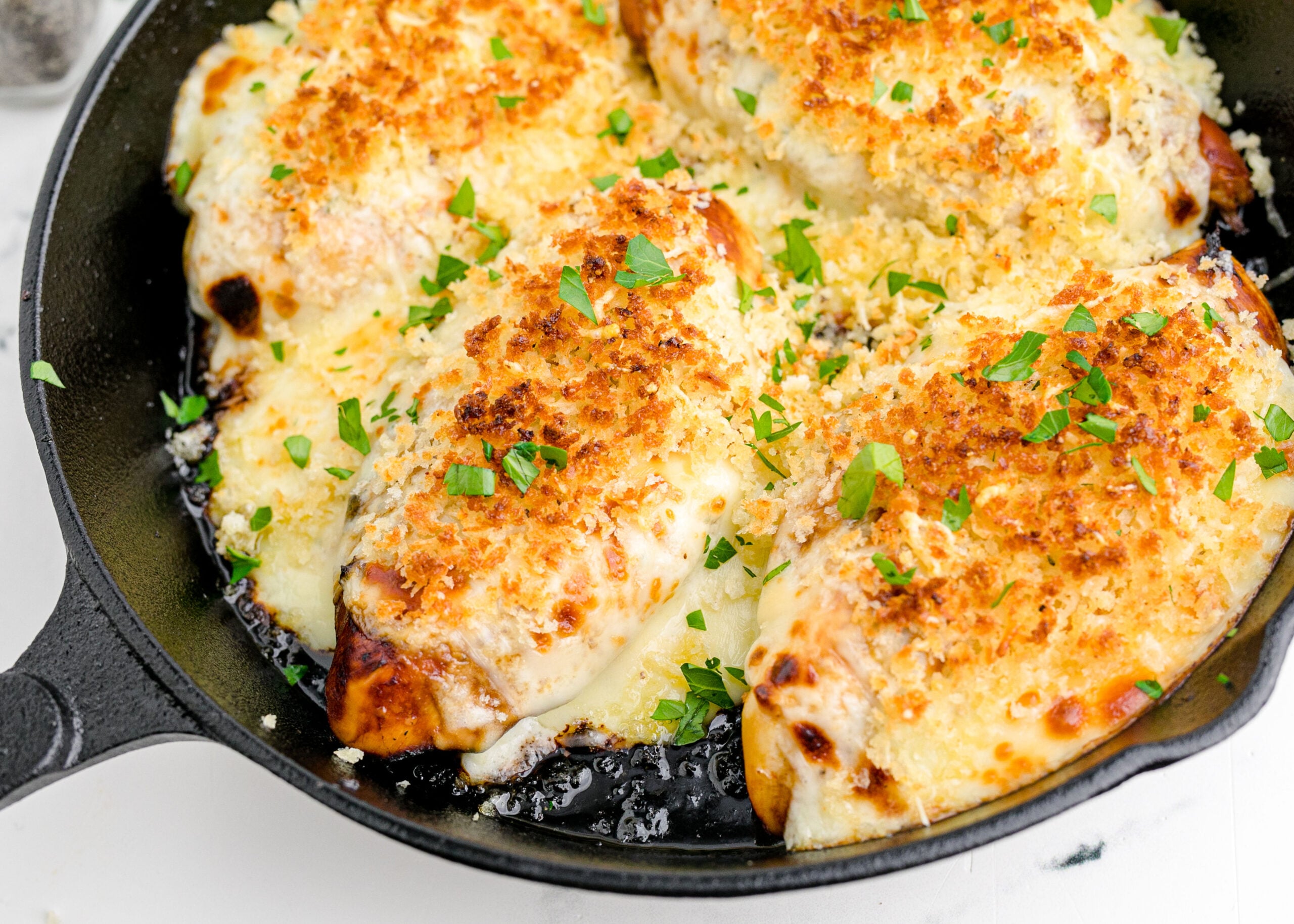 Close up view of Parmesan Crusted Chicken (Longhorn Copycat) in a cast iron skillet.