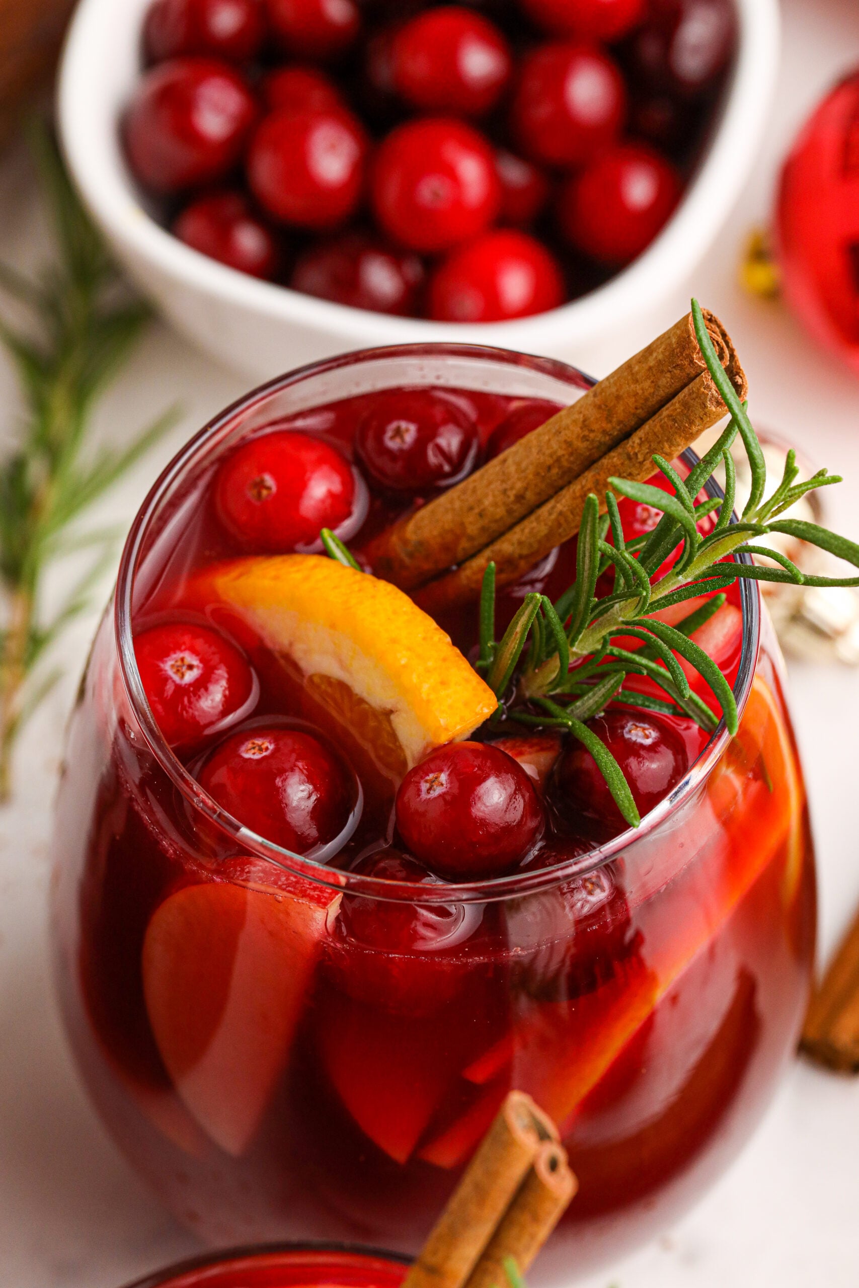 Cranberry Apple Christmas Sangria with fresh cranberries and cinnamon sticks in a clear glass