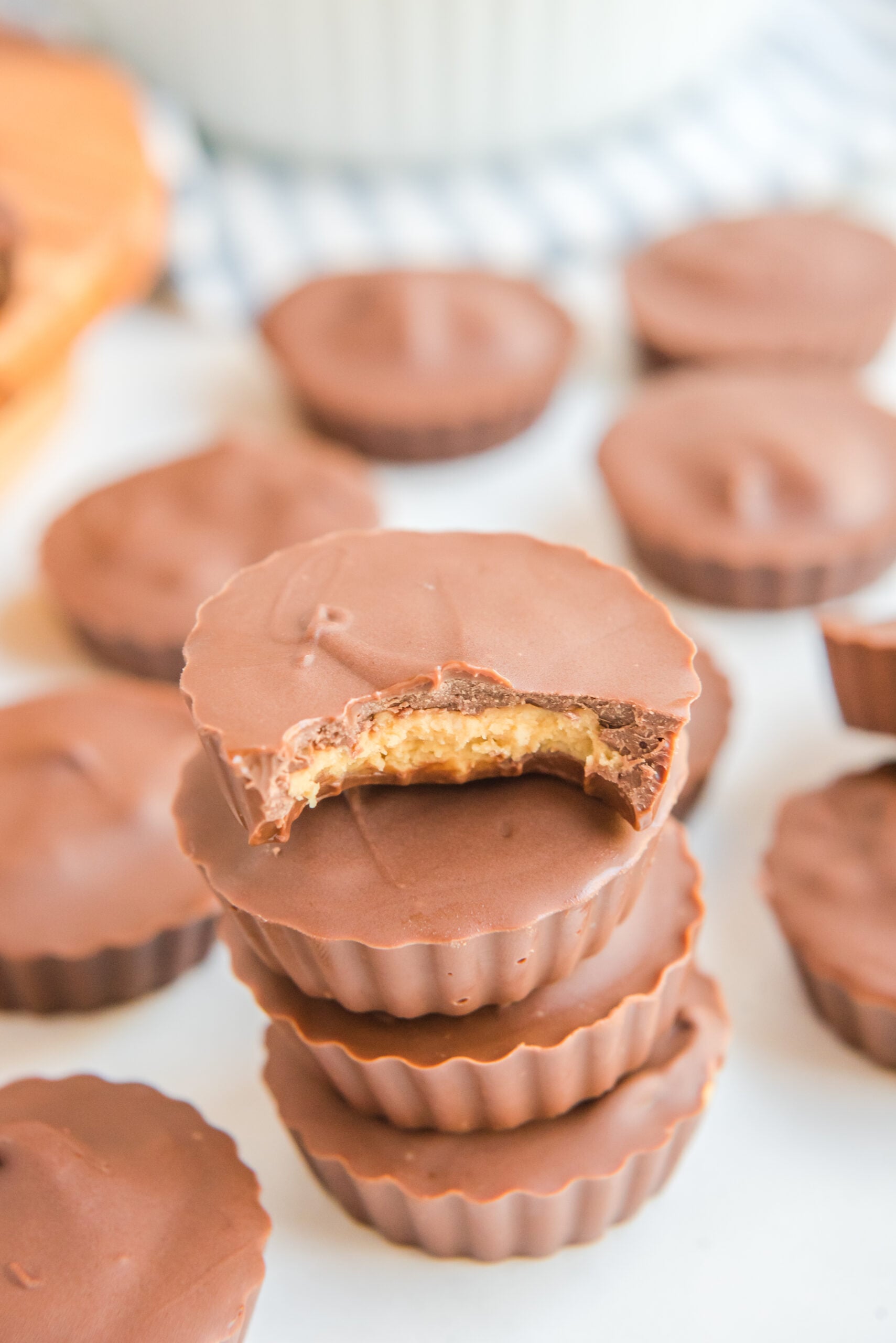 stack of homemade Peanut Butter Cups with a bite missing from the top one showing the inside