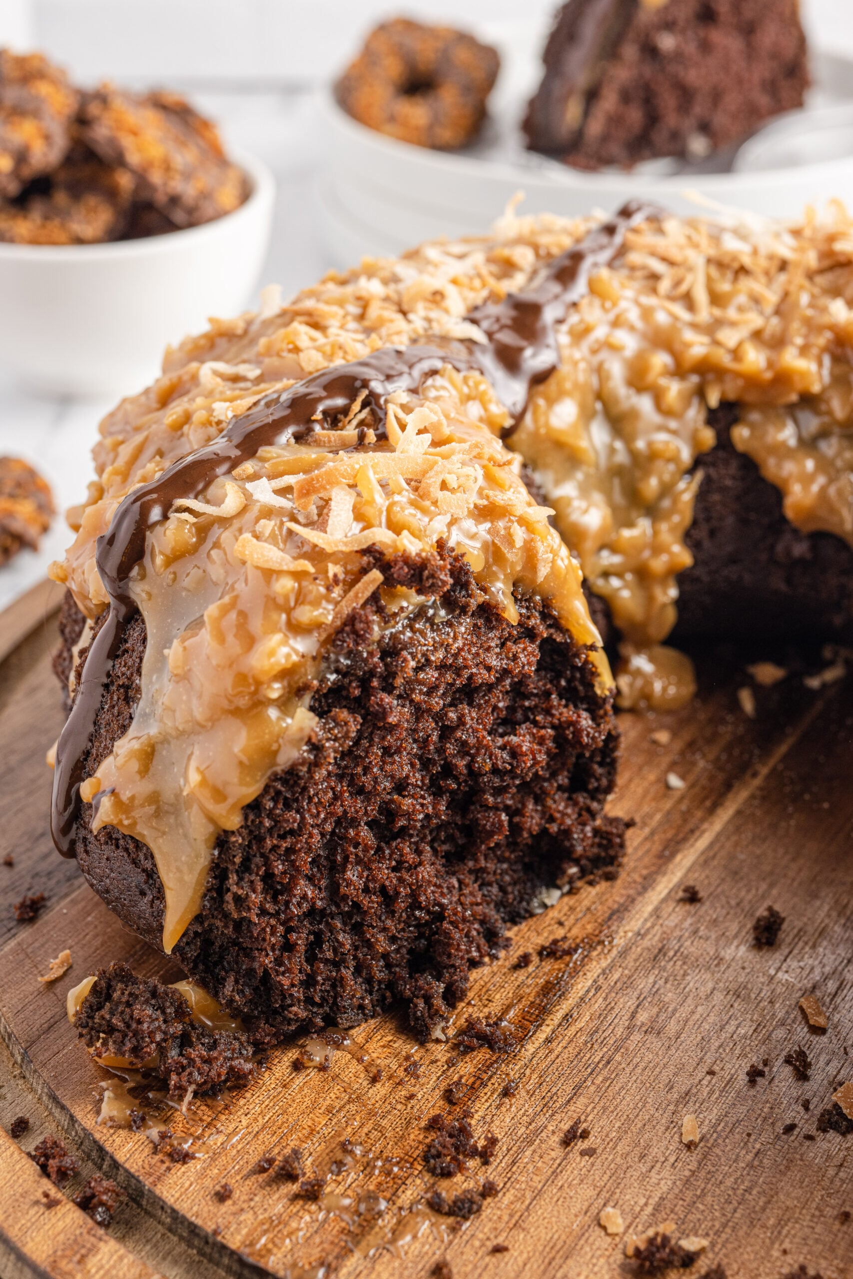 Samoa Cake on a wooden board with a slice missing showing the inside texture