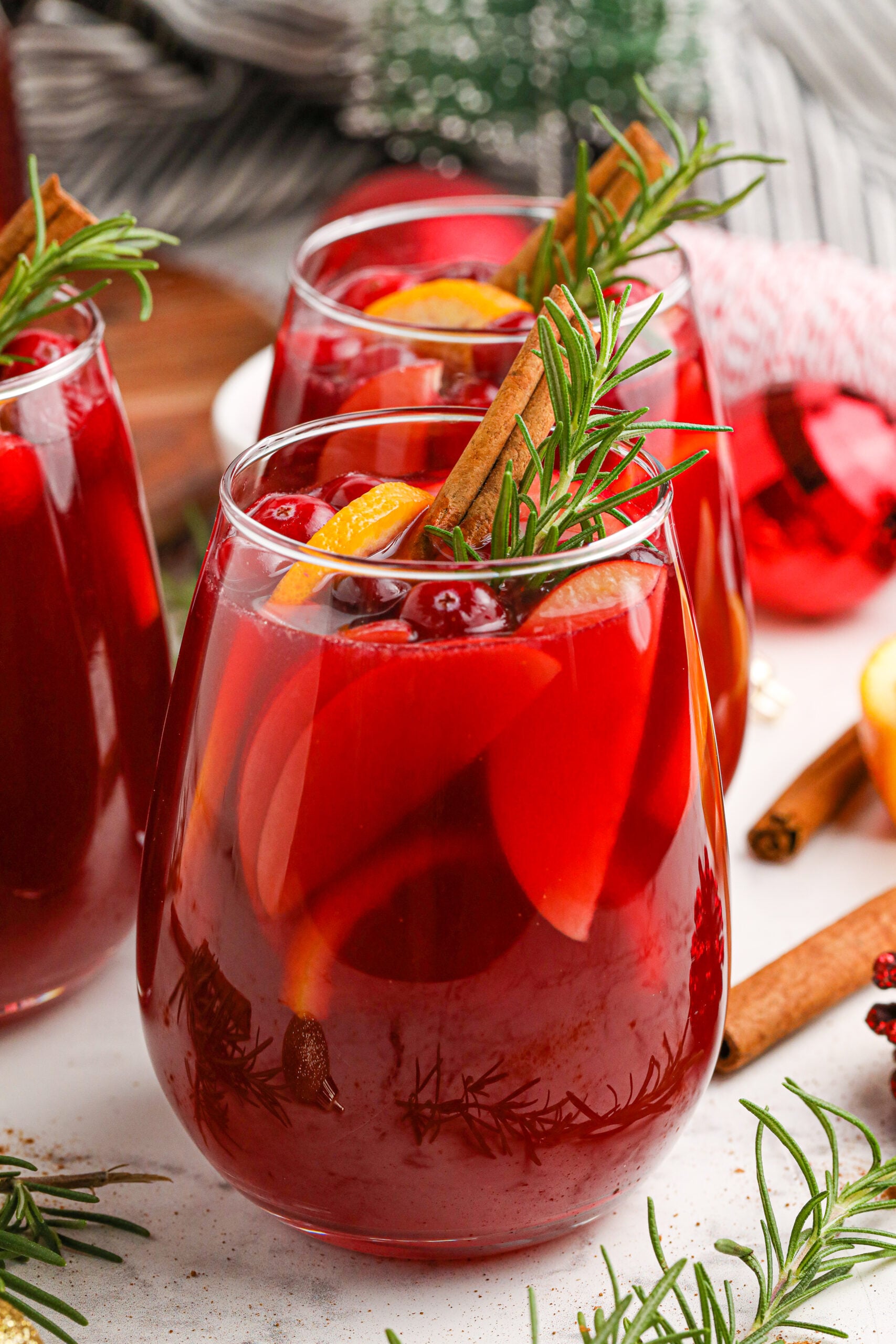 Cranberry Apple Christmas Sangria with fresh cranberries and cinnamon sticks in a clear glass