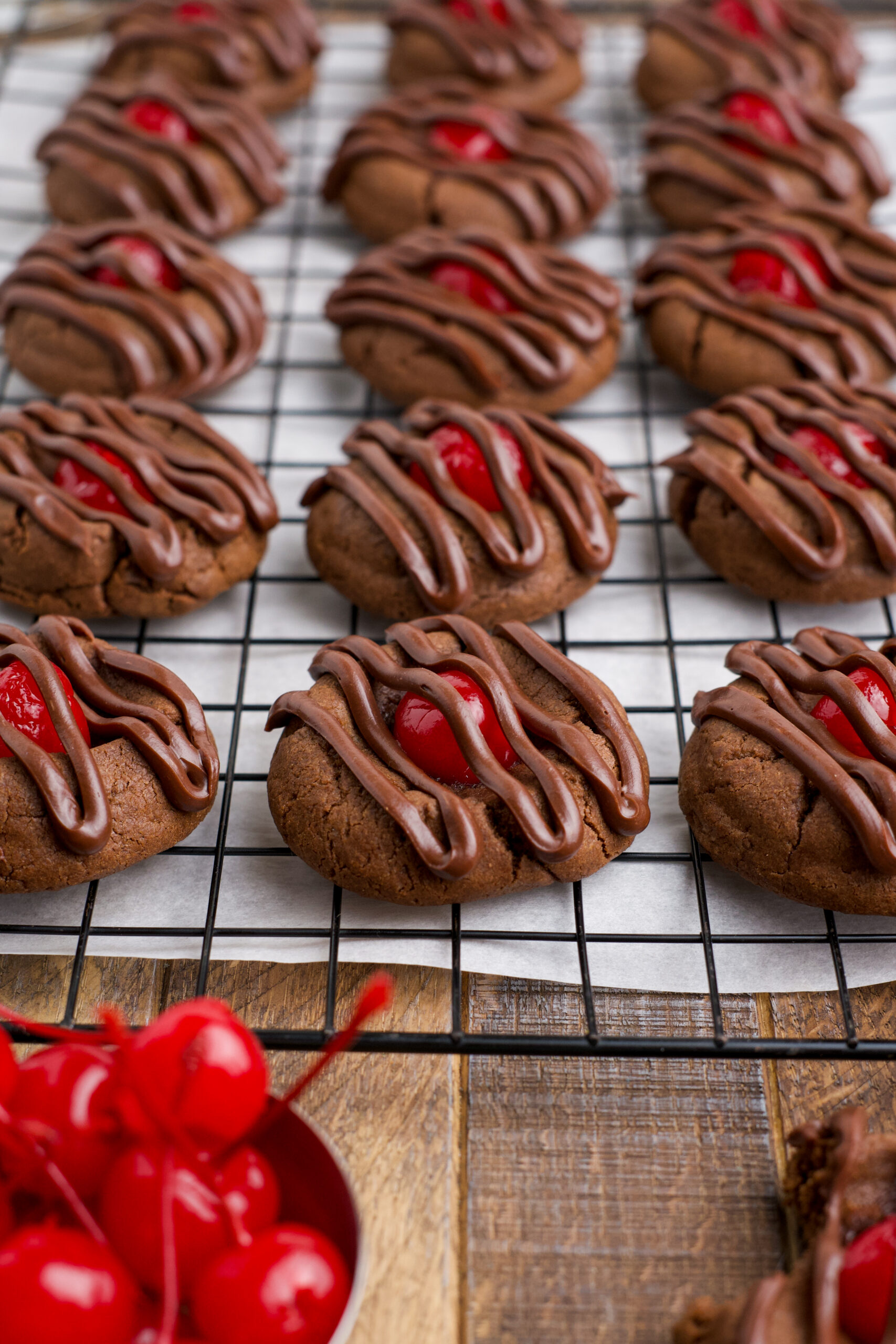 Chocolate Cherry Cookies on a cooling rack topped with a chocolate drizzle 