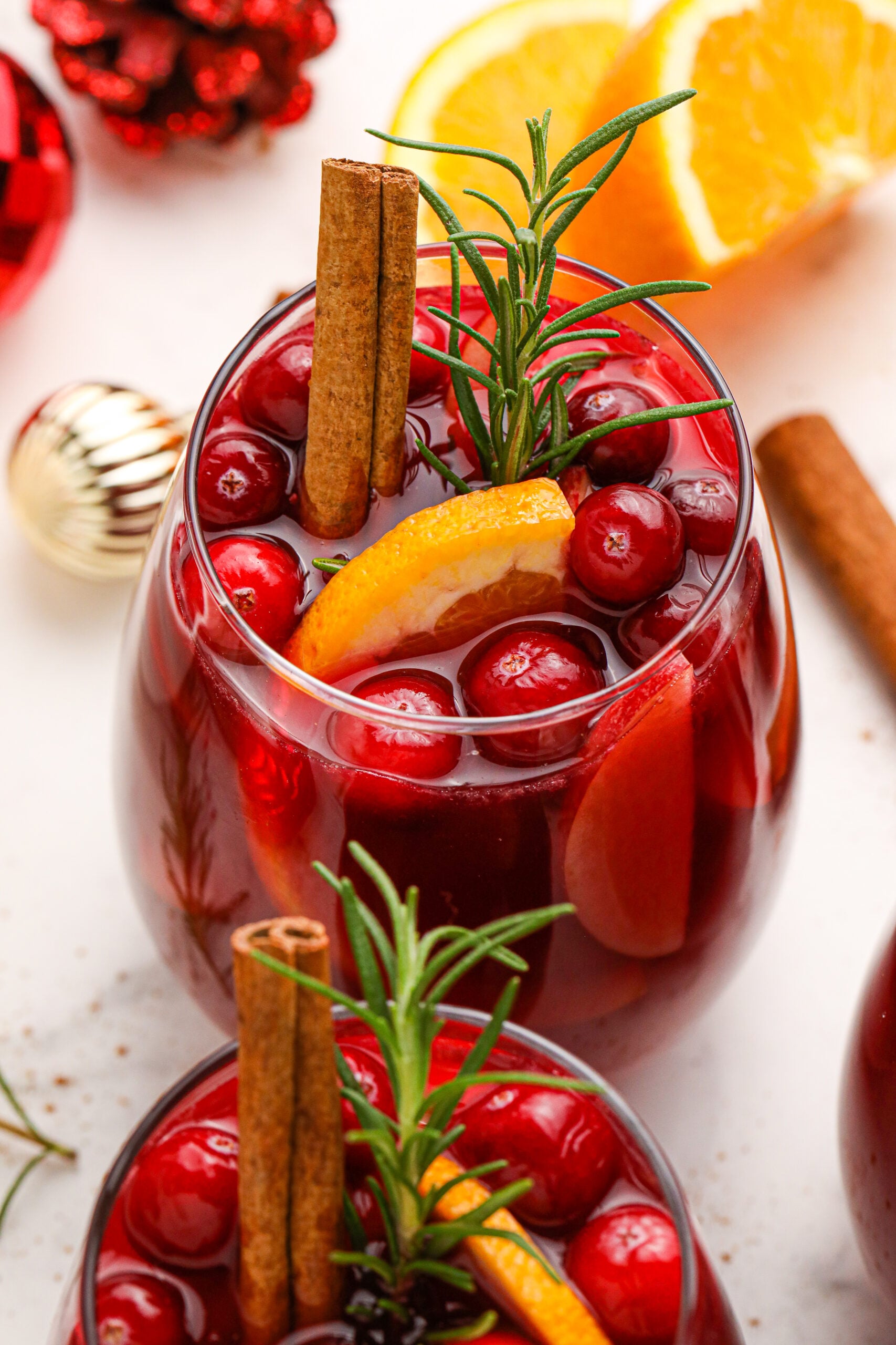 Cranberry Apple Christmas Sangria with fresh cranberries and cinnamon sticks in a clear glass