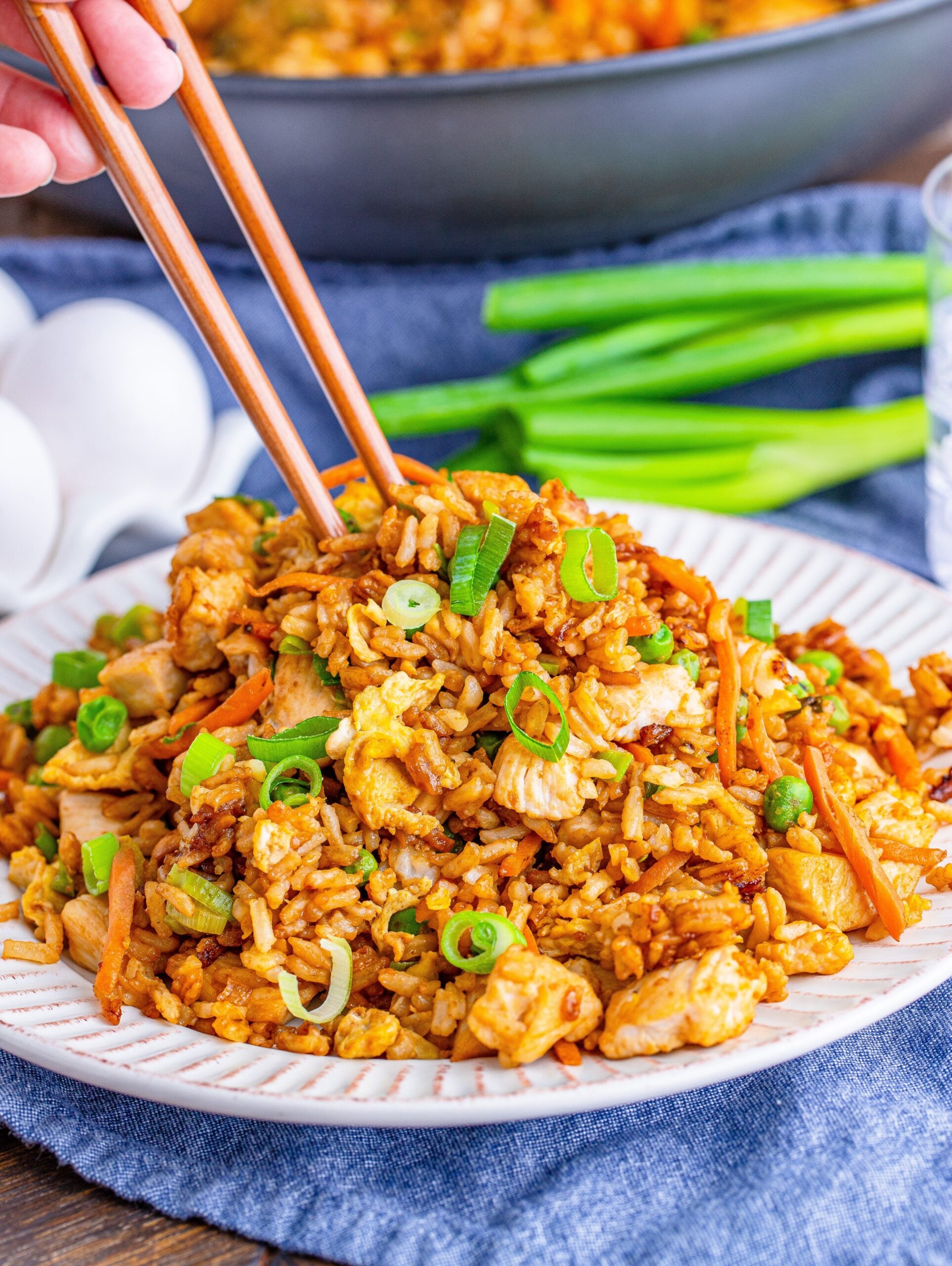 chopsticks with a plate of chicken fried rice