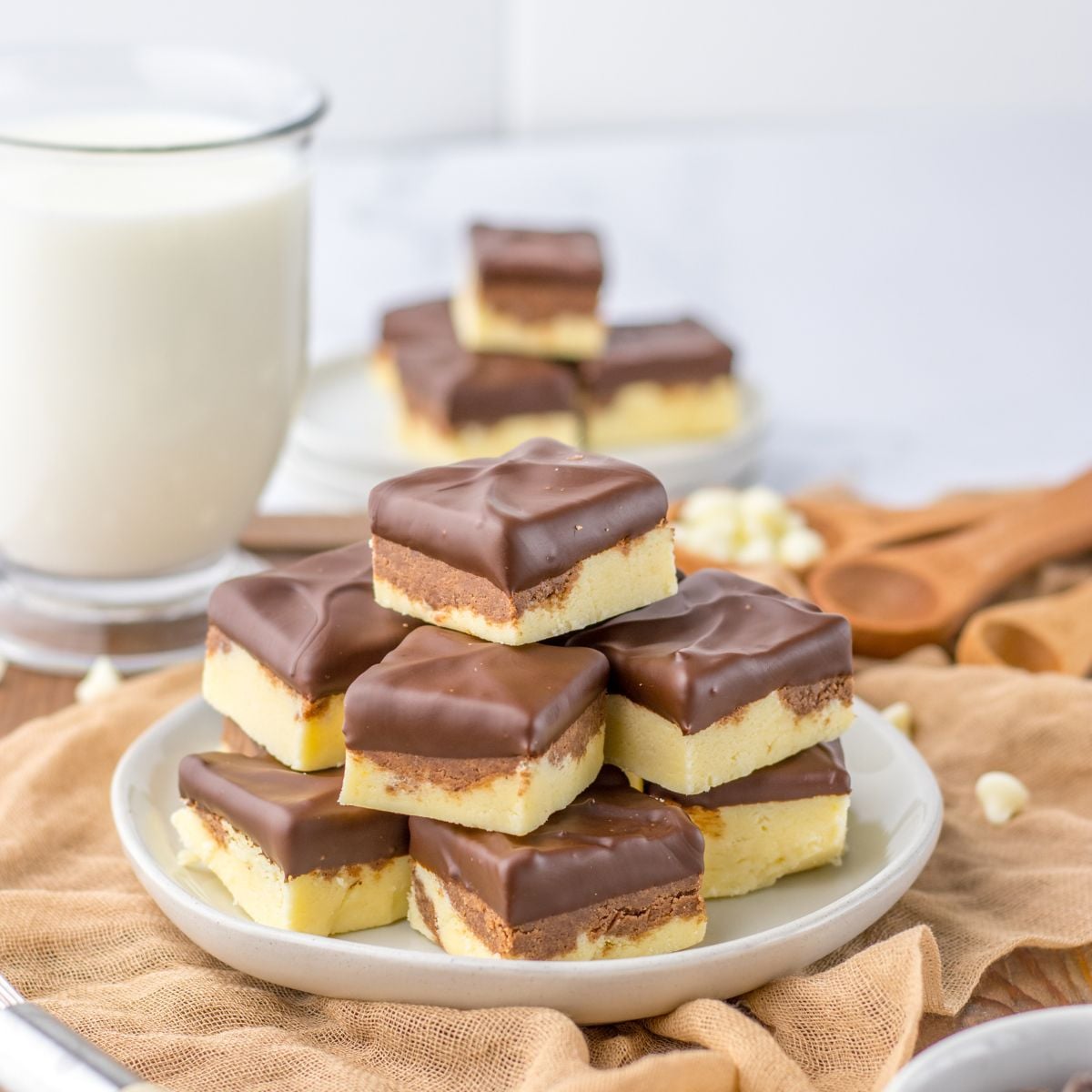 Boston Cream Pie Fudge stacked on table with glass of milk behind it