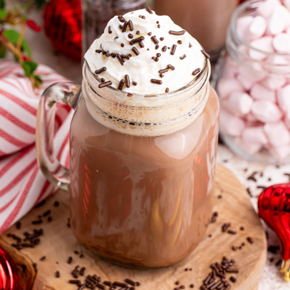 dirty snowman drink in a mug on table with christmas decor behind it and around it