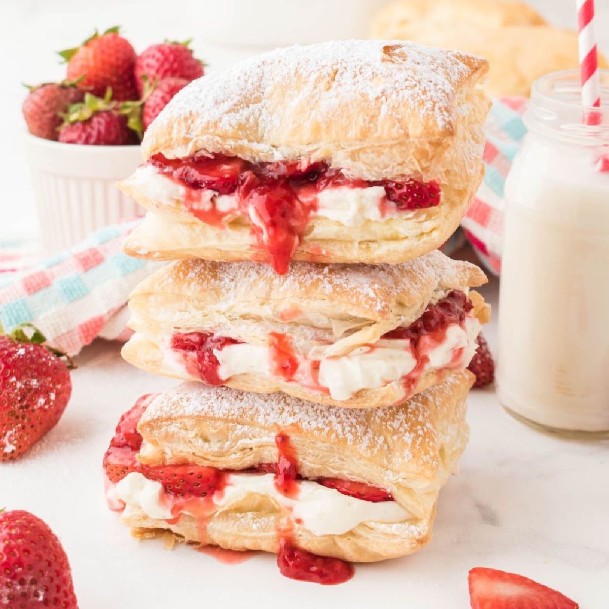 Strawberry flaky puffs stacked on a white plate