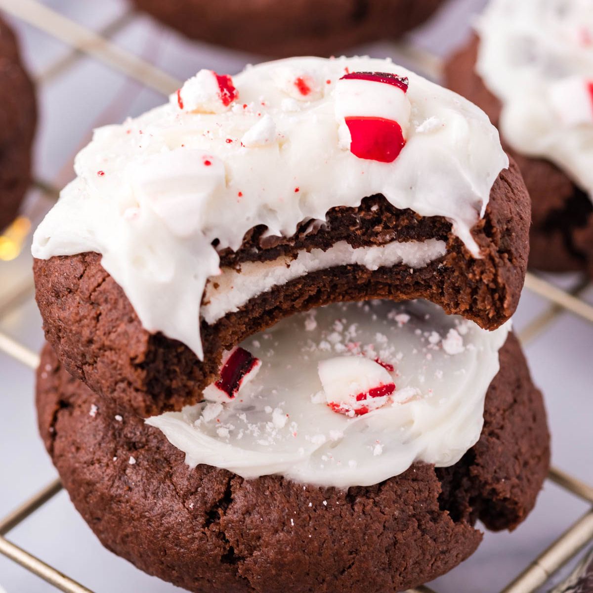 Stuffed Peppermint Patty Cookies stacked on table with a bite taken out of top cookie 