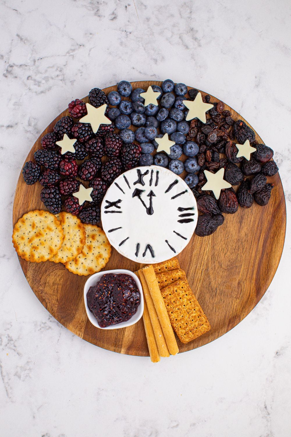 New Year's Eve Charcuterie Board with fruit and crackers spread on a serving tray 